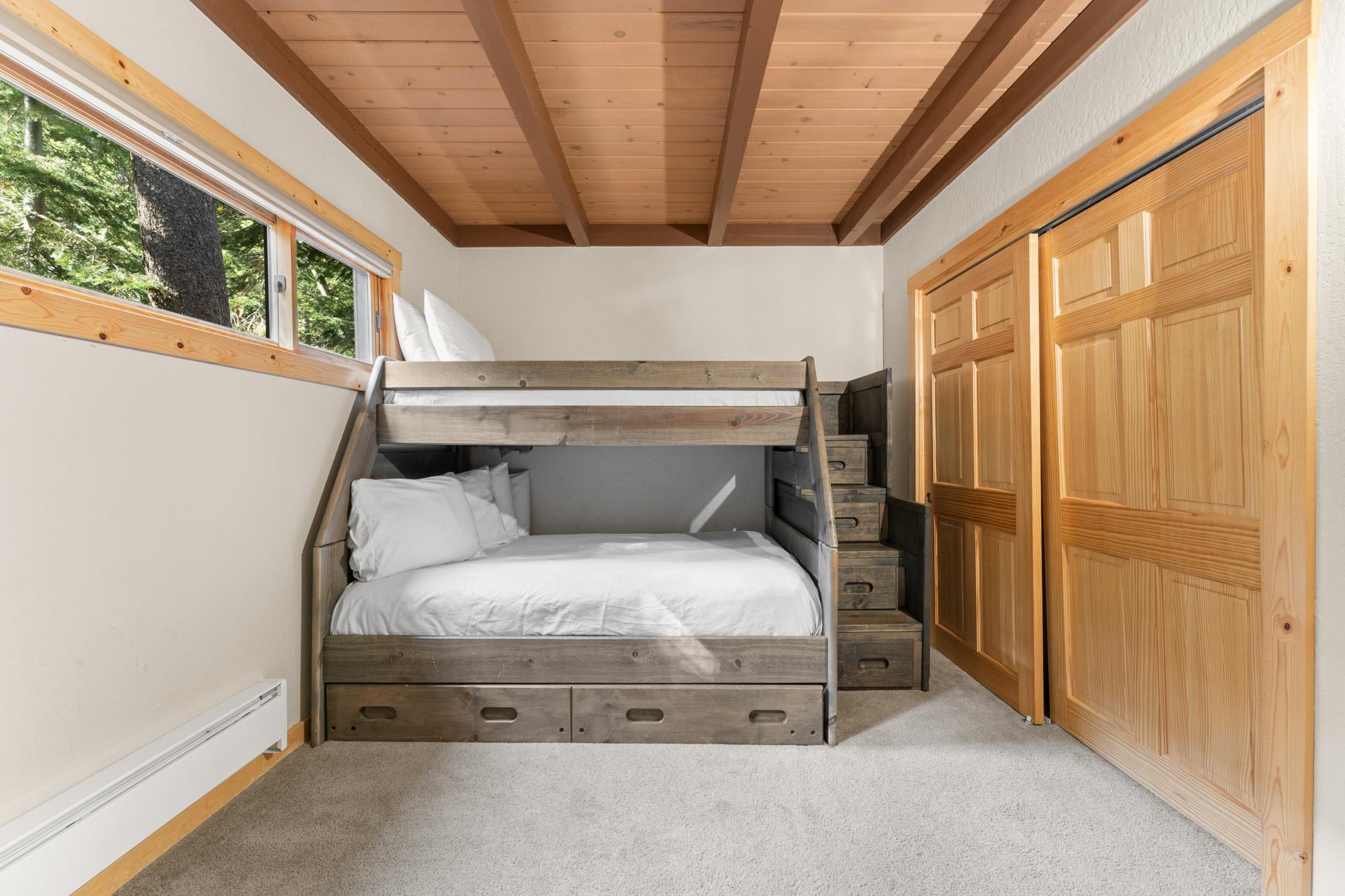 Bunk bed in a bright room with wooden ceiling and closet in Truckee vacation rental.