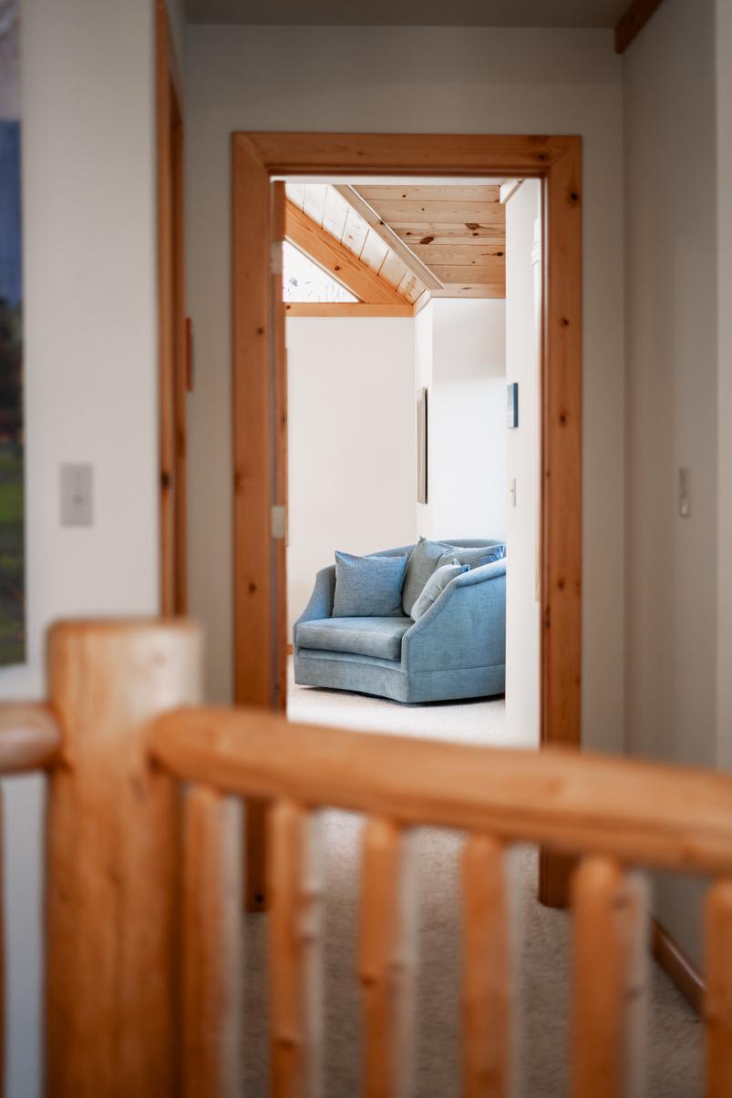 View of a cozy blue chair through a wooden doorway in a Truckee vacation rental home.