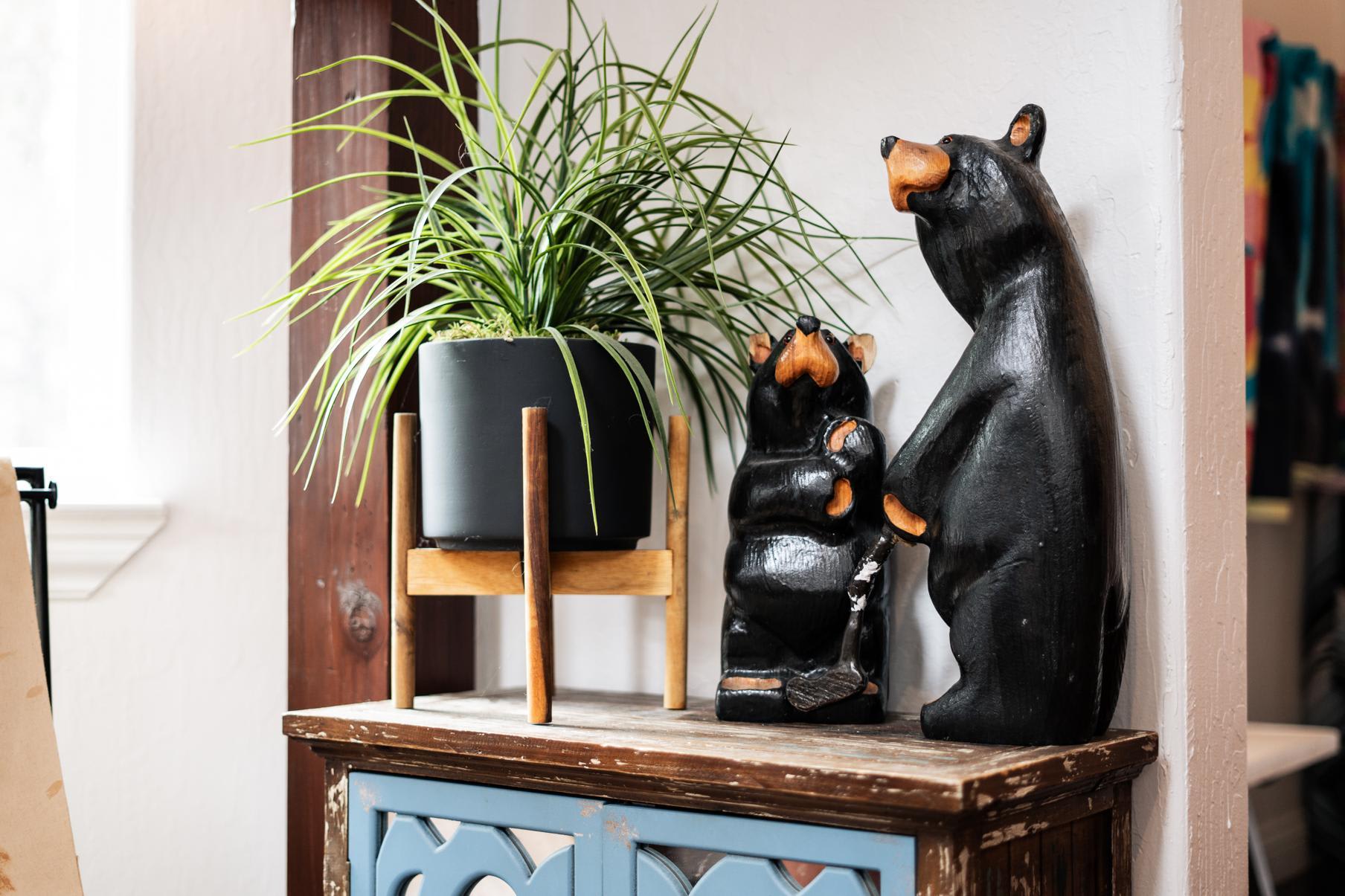 Cozy Truckee vacation rental decor: wooden bear sculptures and a potted plant on a rustic cabinet.