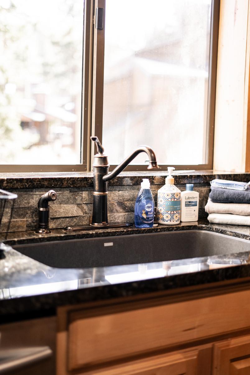 Cozy kitchen sink area in a Truckee vacation rental, featuring dish soap and towels by the window.