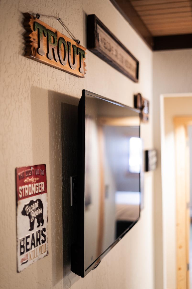 Interior of a Truckee vacation rental with a mounted TV and rustic decor on the wall.