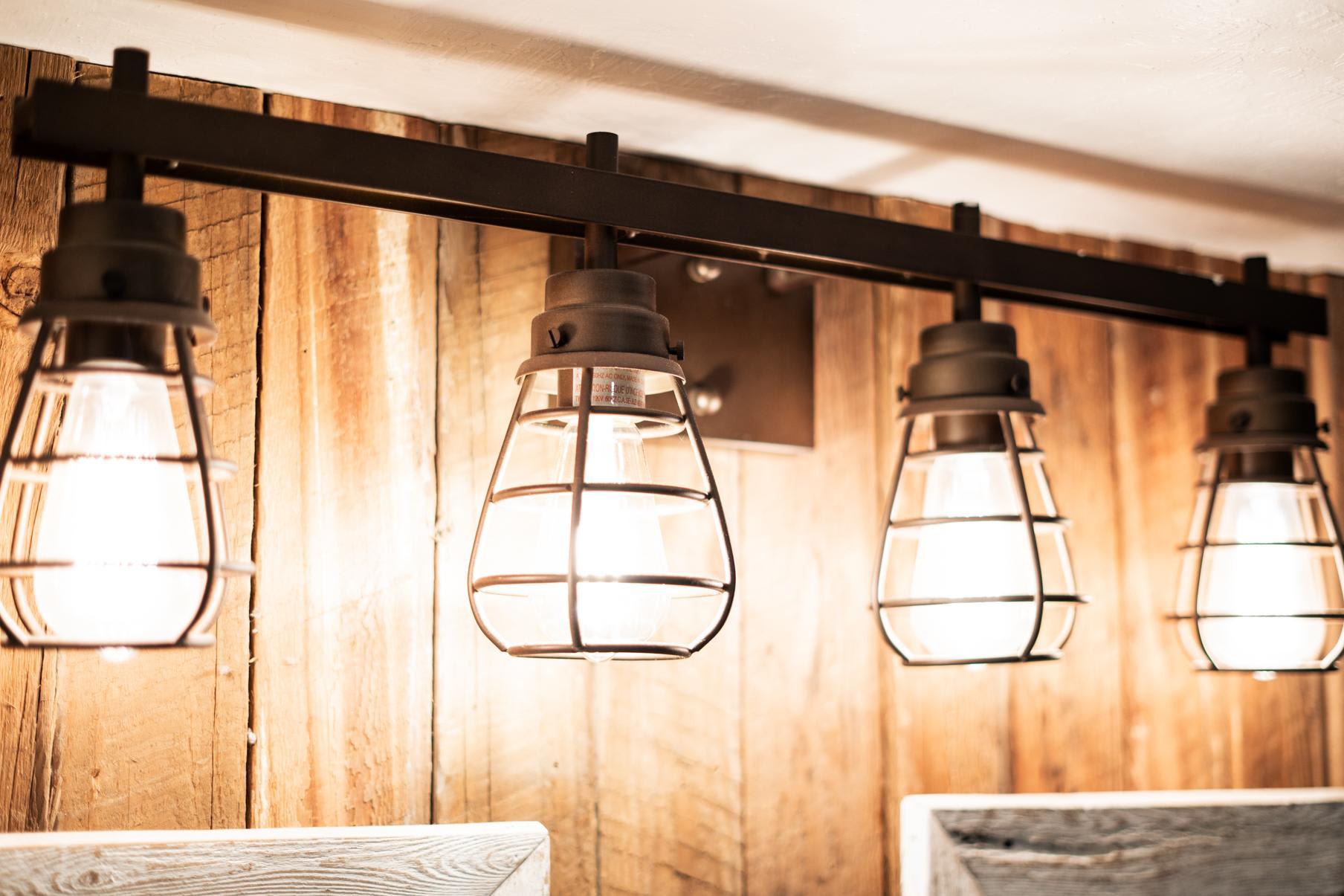 Industrial-style light fixture in a Truckee vacation rental, featuring warm wooden walls and vintage bulb design.