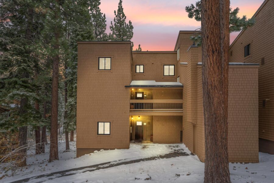 Wooden vacation rental in snowy forest setting, Truckee, at sunset.