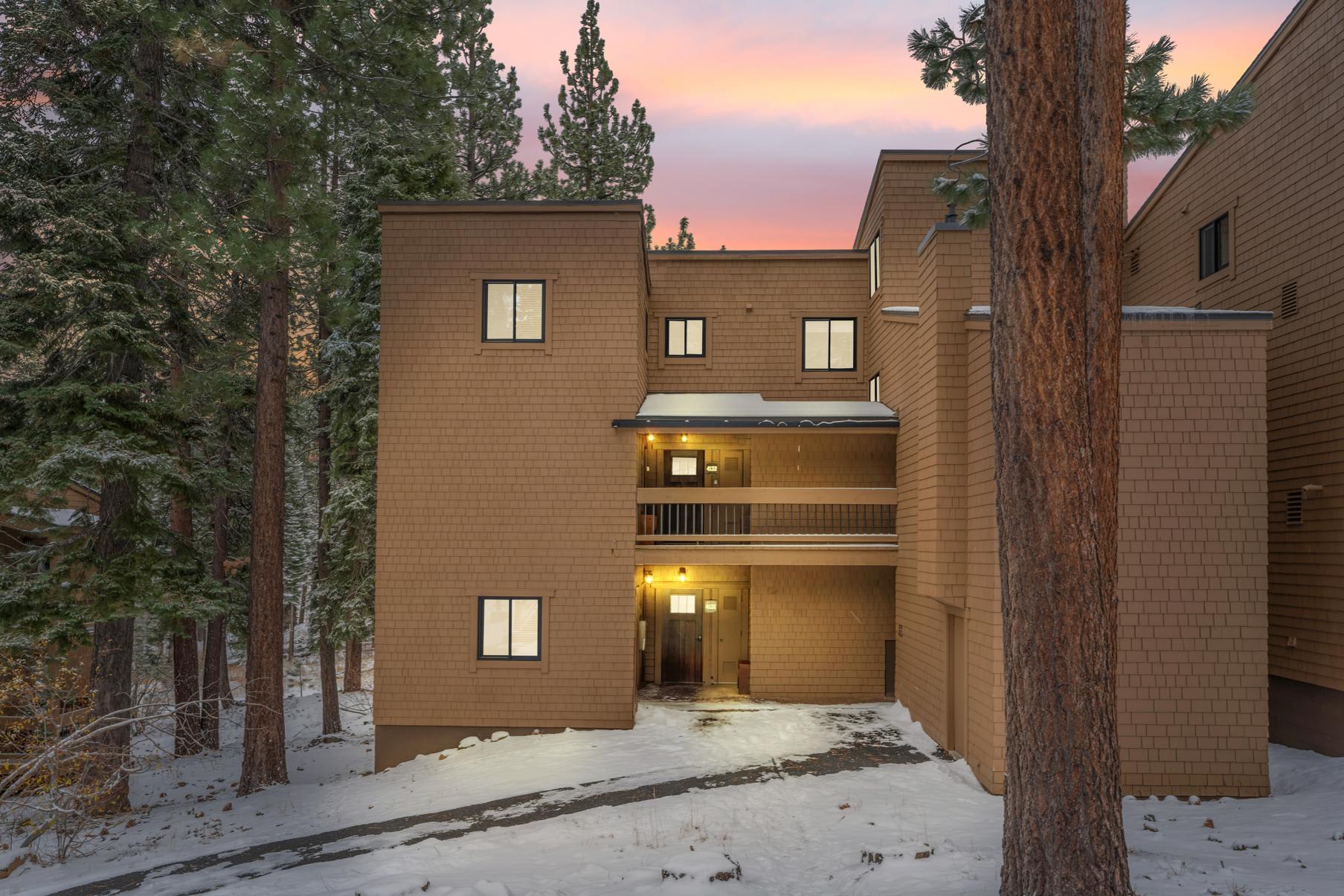 Wooden vacation rental in snowy forest setting, Truckee, at sunset.