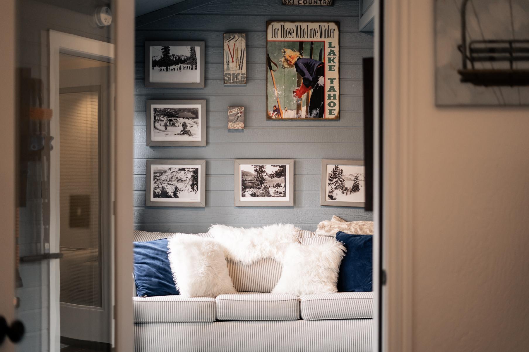 Cozy living room in a Truckee vacation rental with vintage Lake Tahoe decor and plush pillows on a striped sofa.