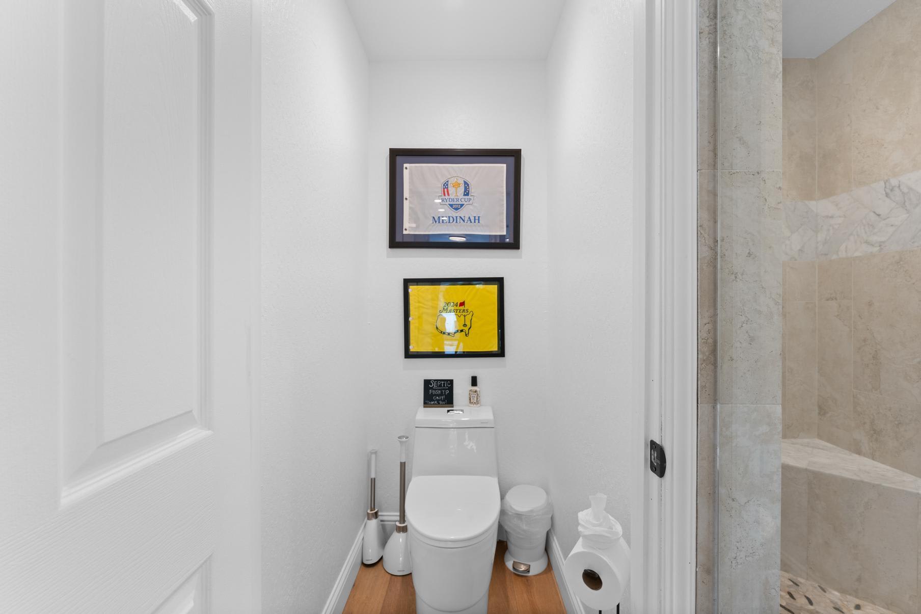 Bathroom in a Truckee vacation rental featuring modern decor, wood flooring, and framed artwork on white walls.