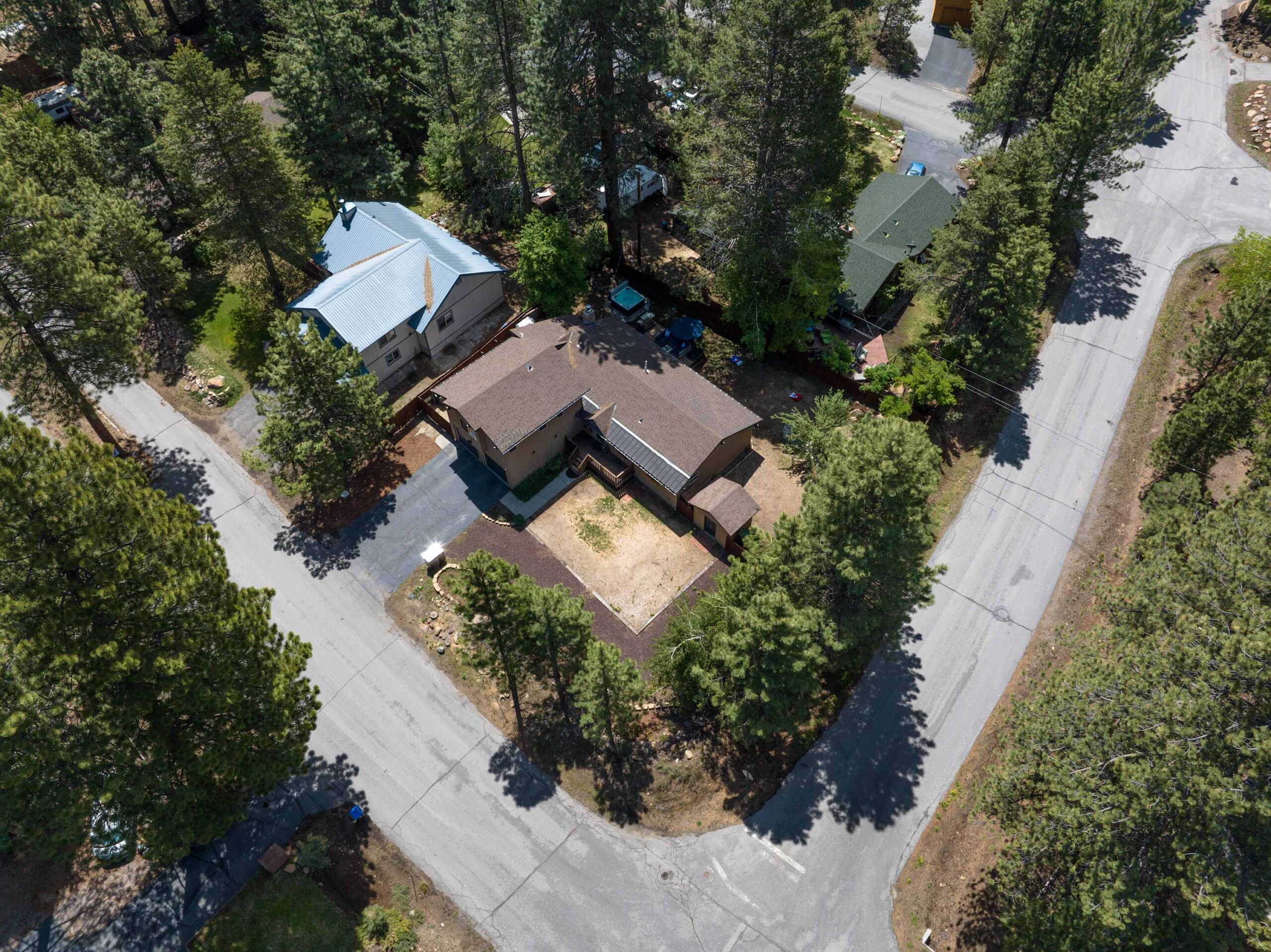 Aerial view of a vacation rental surrounded by trees in a residential neighborhood of Truckee.