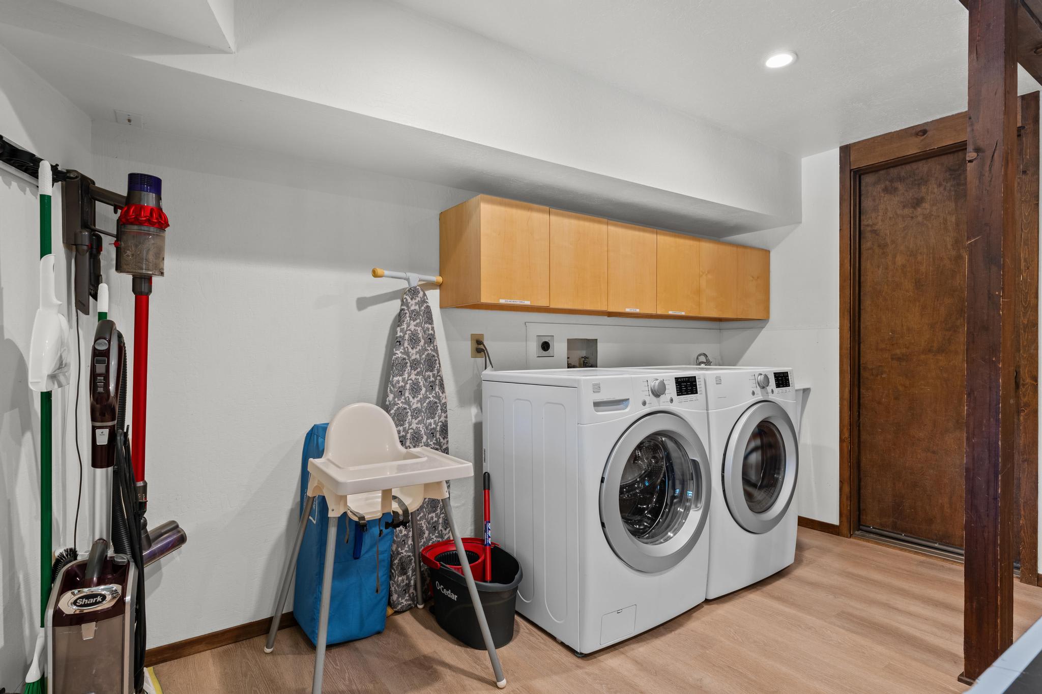 Laundry room in Tahoe Vista vacation rental with washer, dryer, and cleaning supplies.
