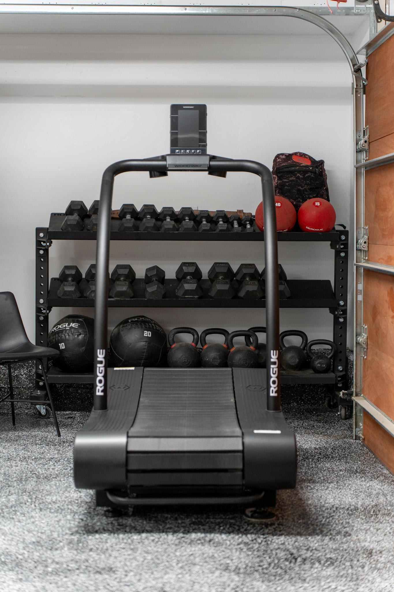 Treadmill and weights in a Truckee vacation rental gym, featuring kettlebells, dumbbells, and medicine balls.