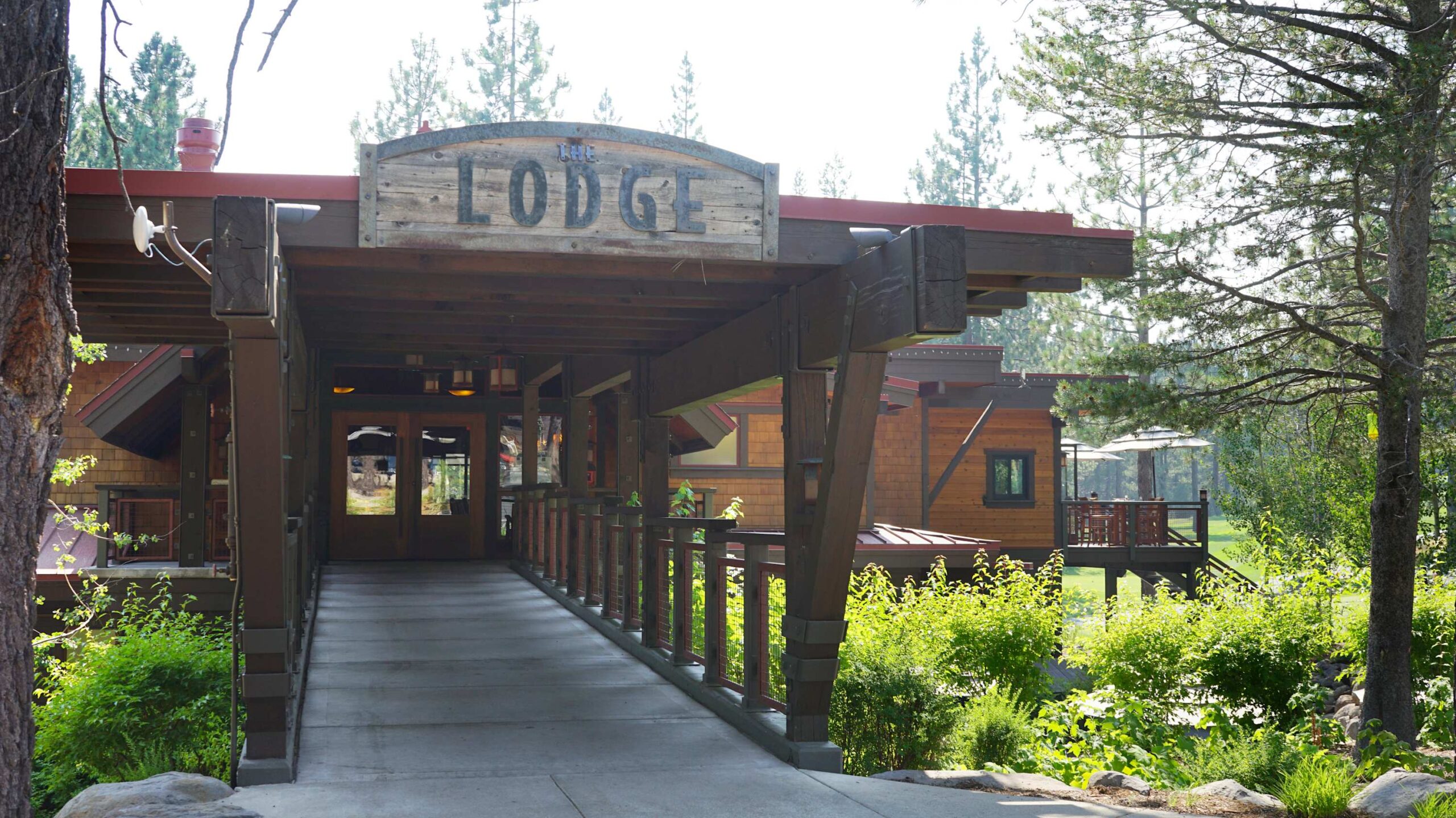 Rustic lodge entrance surrounded by greenery in Truckee, ideal vacation rental for nature lovers.