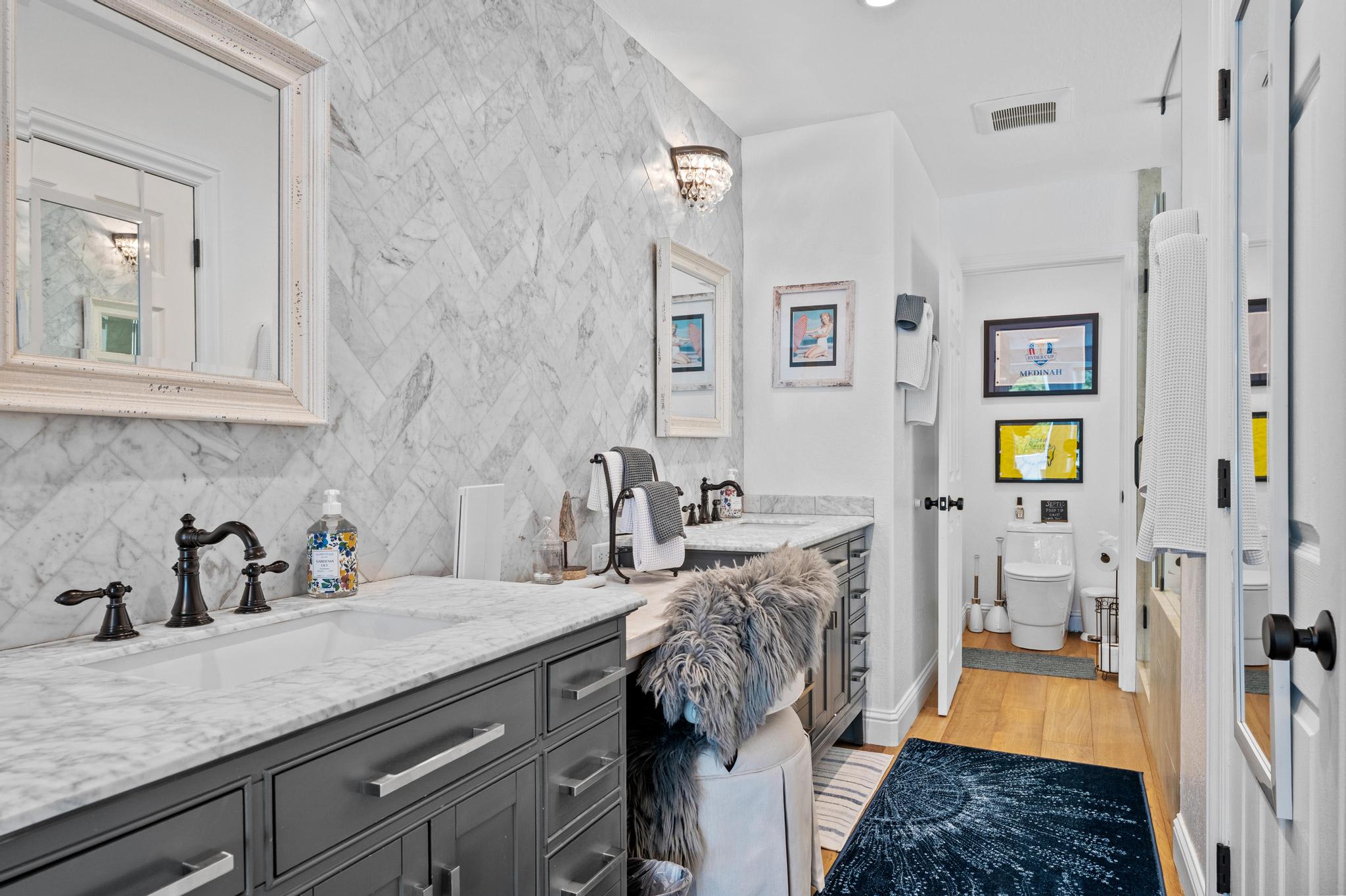 Marble bathroom in Truckee vacation rental featuring sleek fixtures, dark cabinetry, and decorative mirrors.
