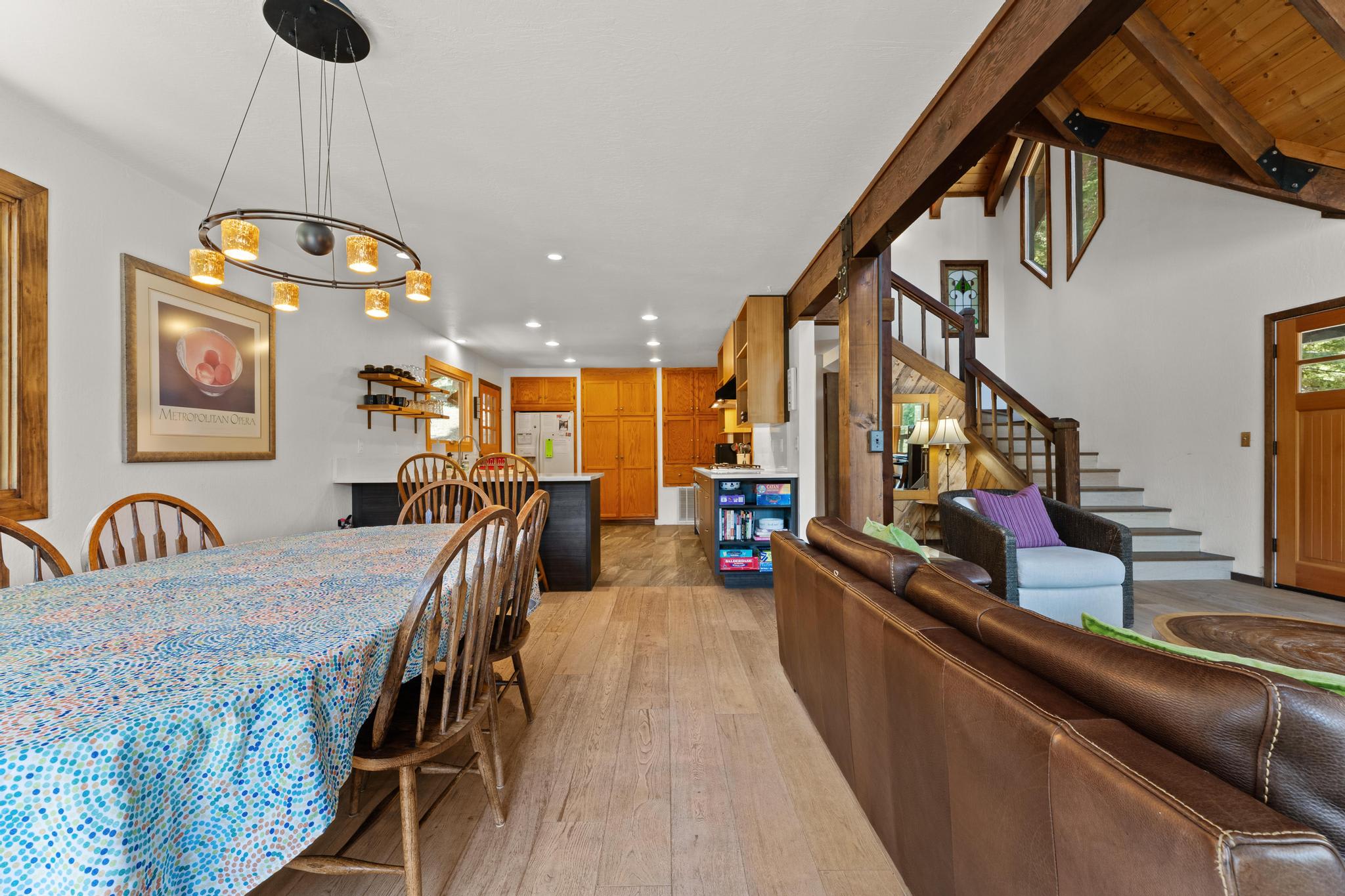 Spacious Tahoe Vista vacation rental with wooden dining table, cozy seating, and modern kitchen in a rustic setting.