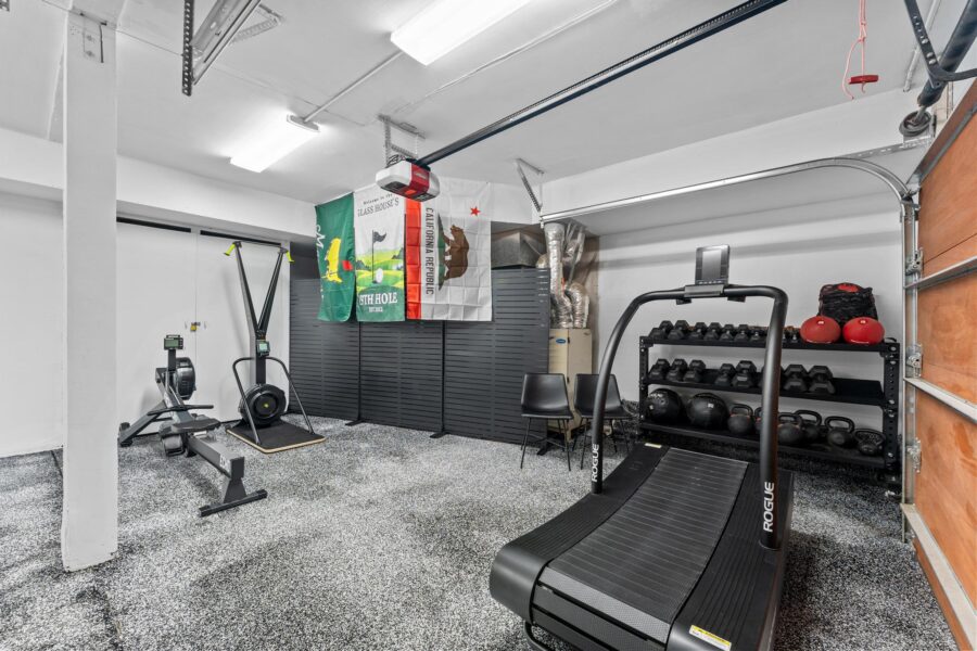 Home gym in Truckee vacation rental with treadmill, rowing machine, weights, and workout equipment.