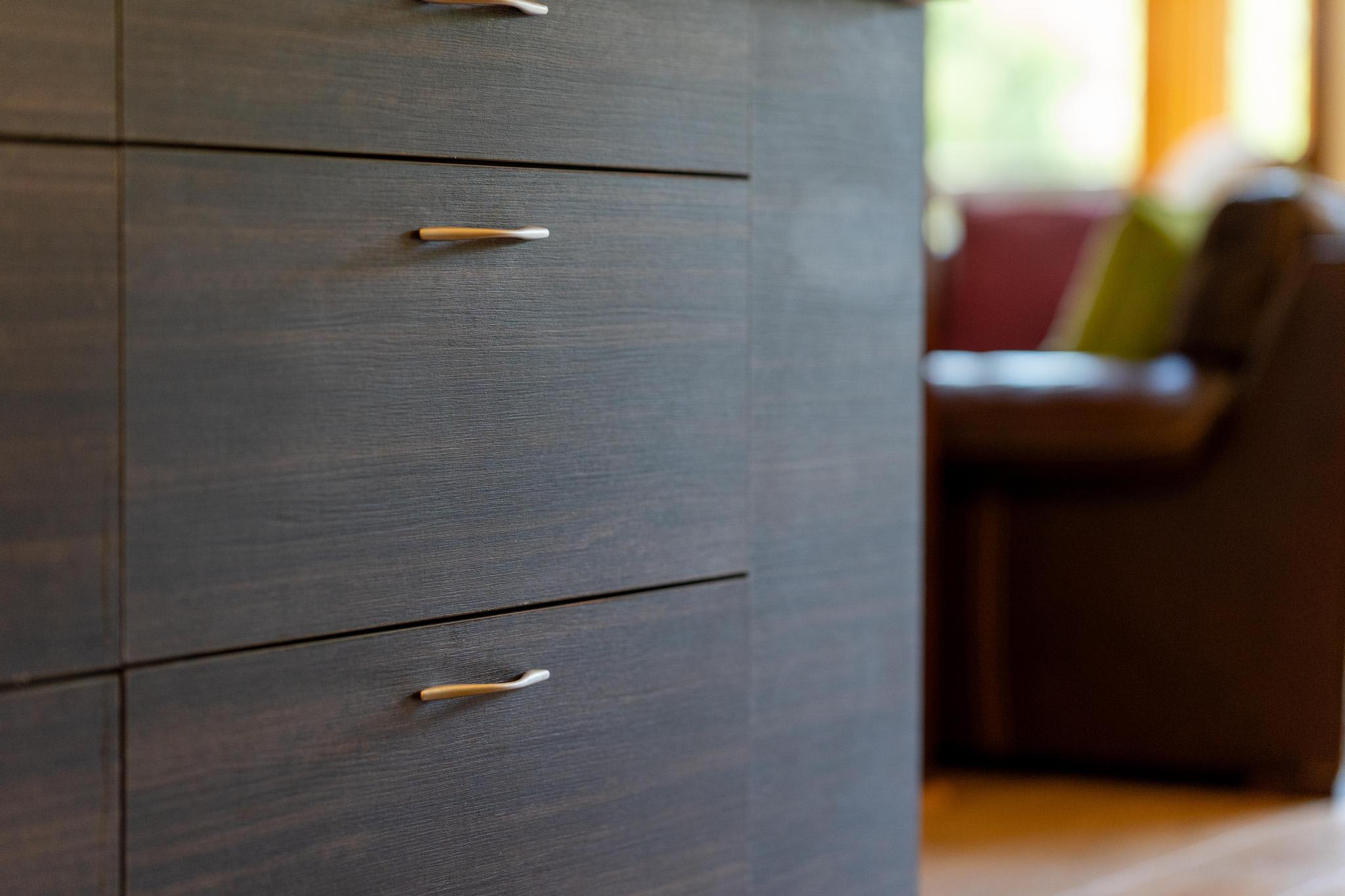 Close-up of a modern kitchen drawer in a Tahoe Vista vacation rental, with blurred seating area in the background.
