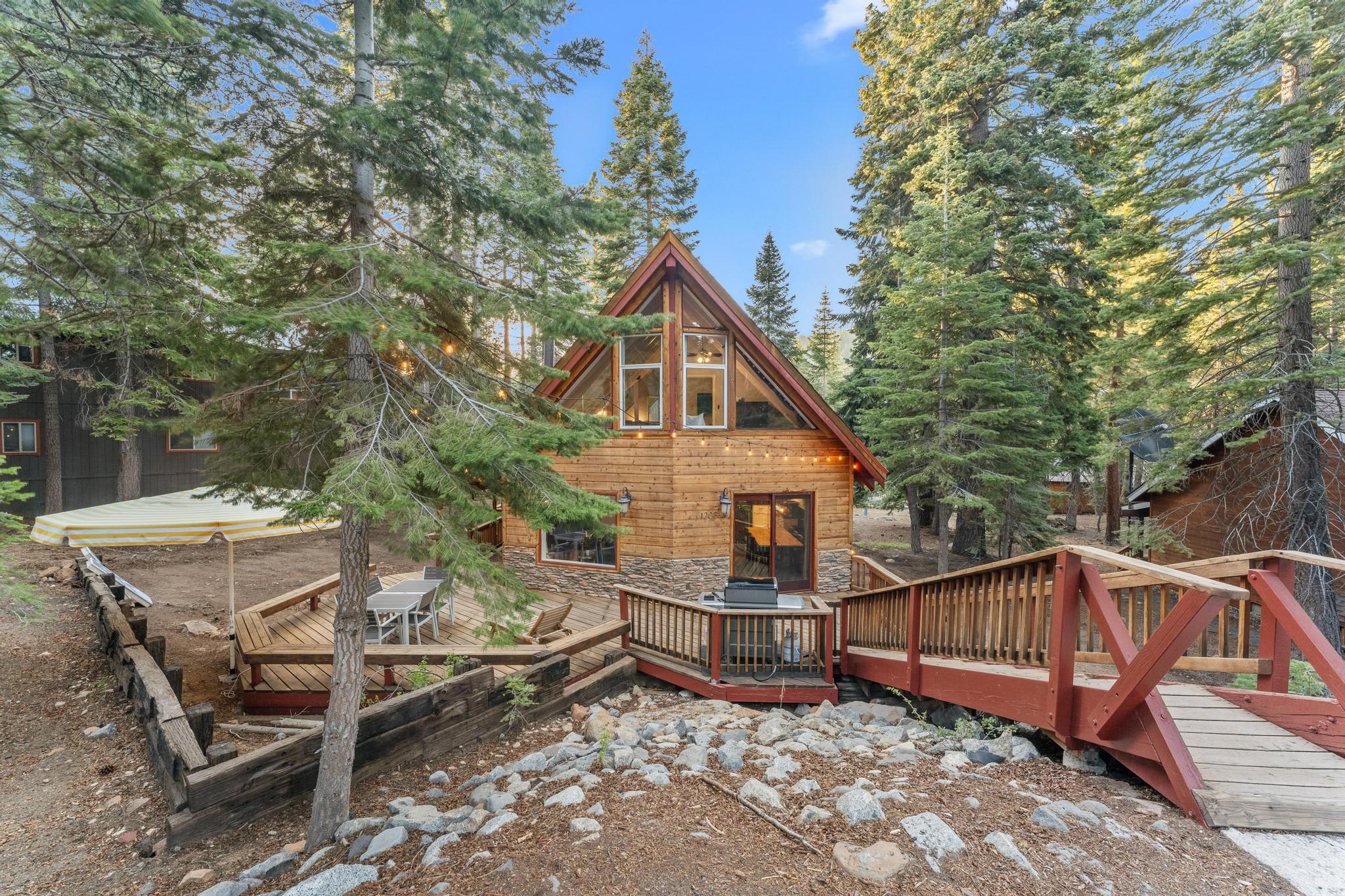 A cozy wooden cabin surrounded by trees in Tahoe Vista, featuring a deck, ideal for a vacation rental retreat.