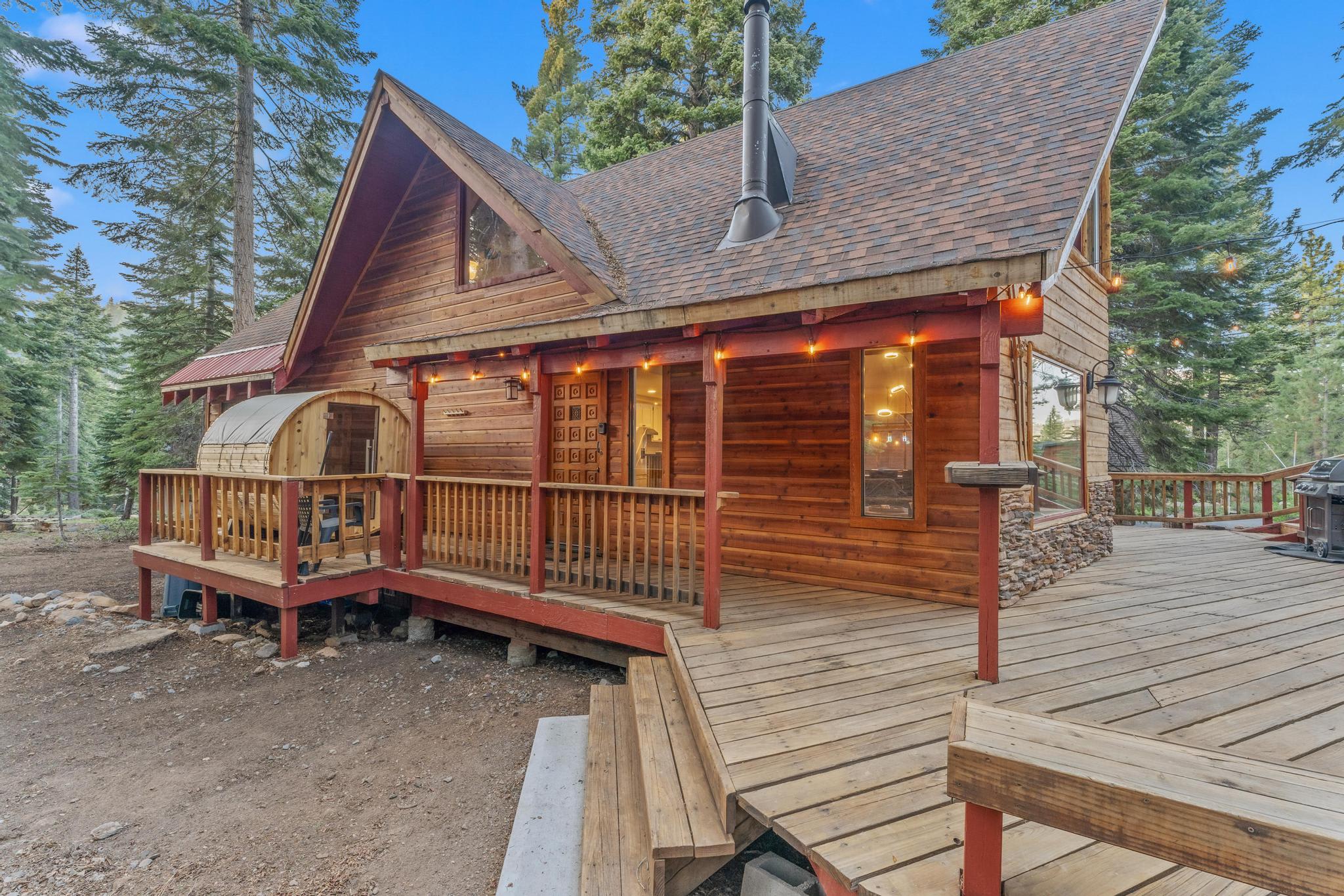Rustic wooden cabin vacation rental with porch in Tahoe Vista, surrounded by tall trees and serene nature views.