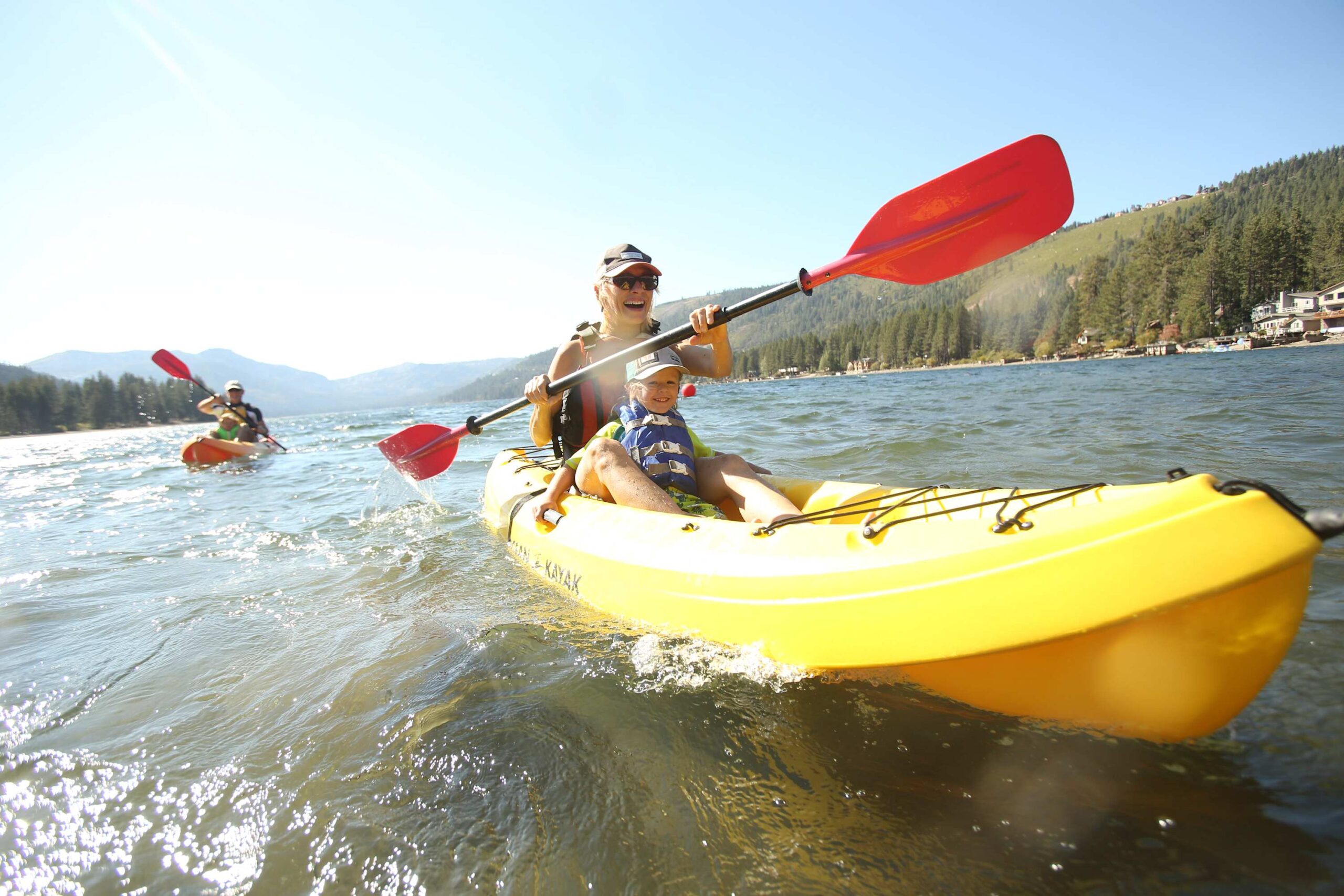 A family kayaking on a lake near Truckee, enjoying the scenic view from their vacation rental.