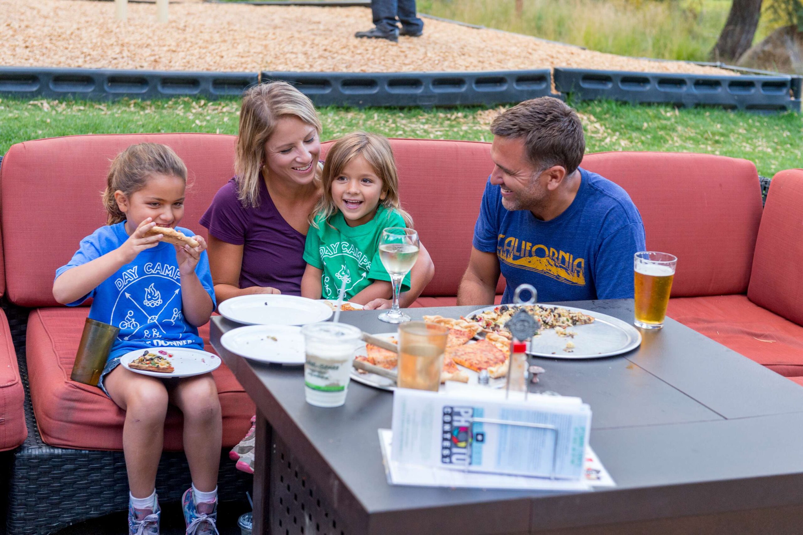 Family enjoying pizza and drinks at a Truckee vacation rental with cozy outdoor seating.