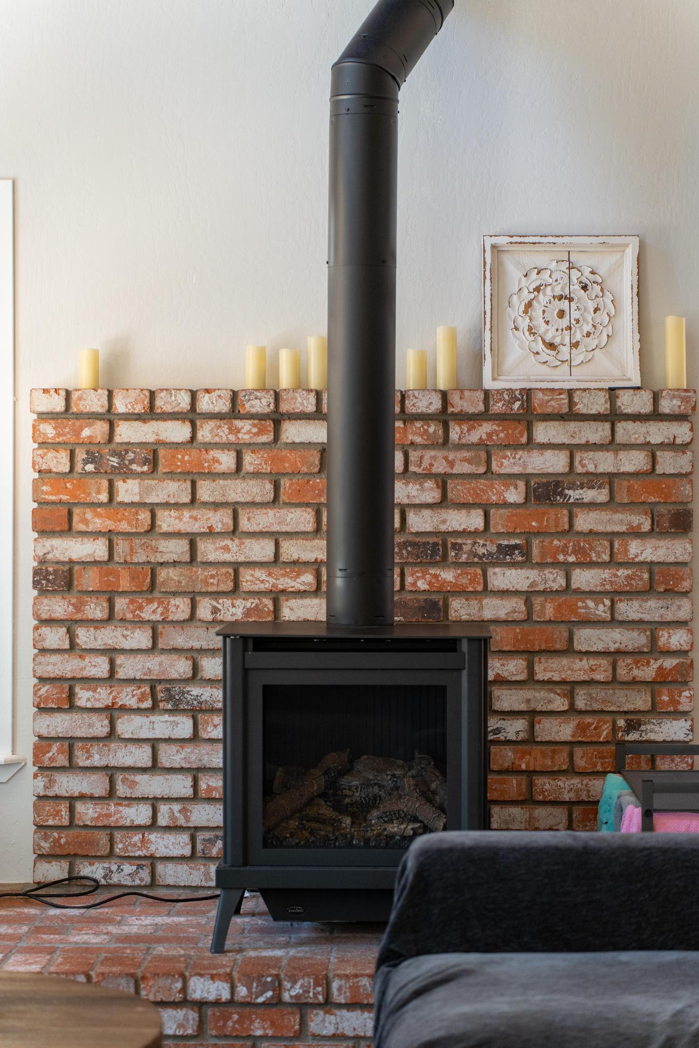 Cozy brick fireplace with candles in a Tahoe Vista vacation rental living room.