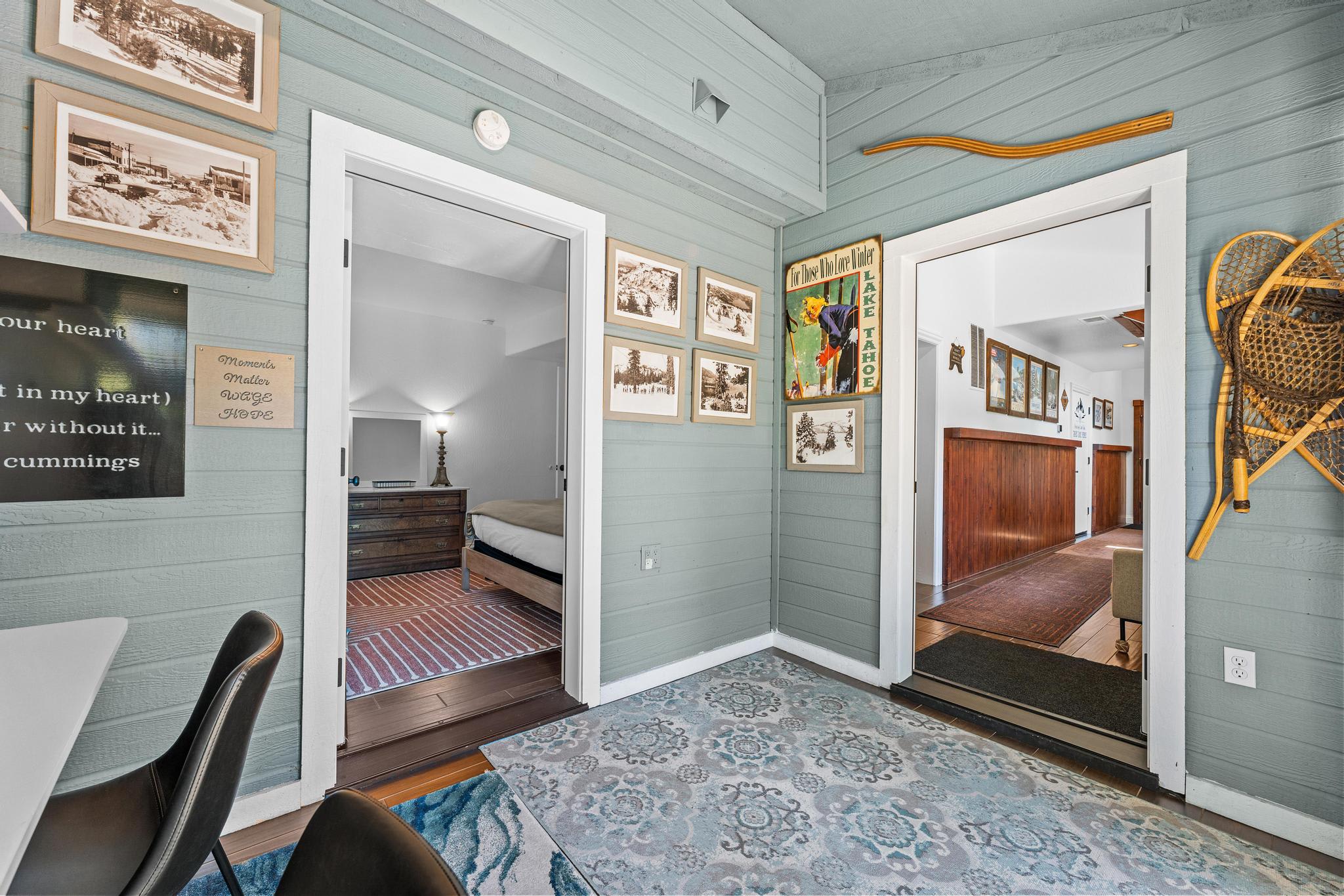 Cozy Truckee vacation rental interior with wall art, snowshoes, and a glimpse into a bedroom and hallway.