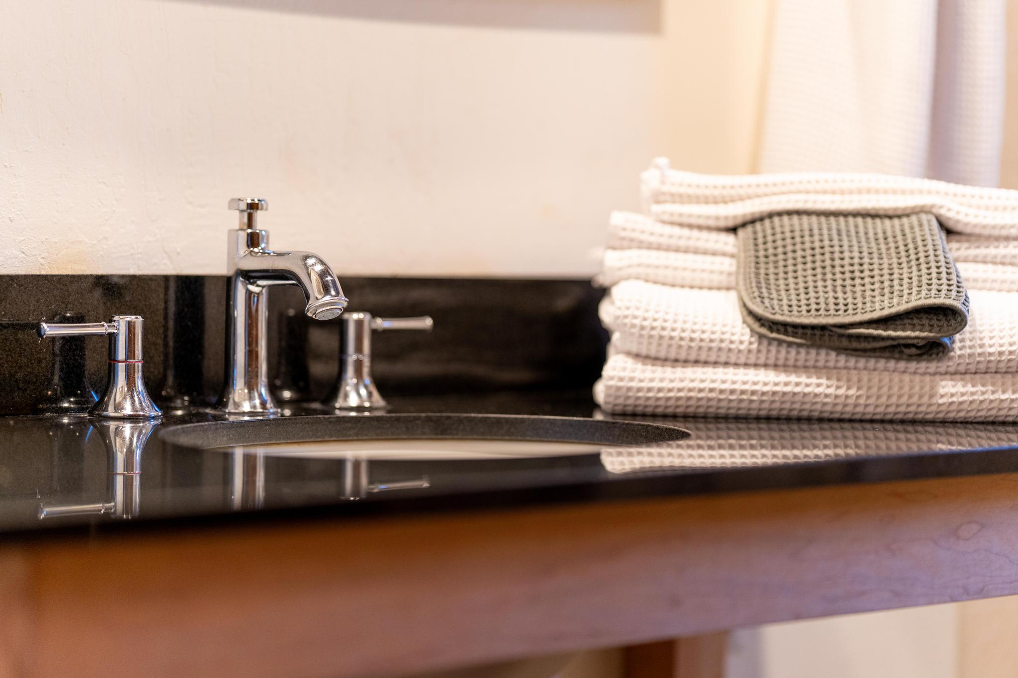 Modern bathroom sink with stacked towels in Tahoe Vista vacation rental.