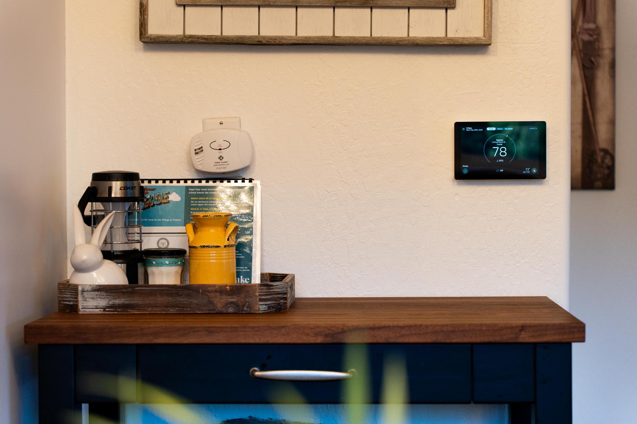 Cozy corner in a Truckee vacation rental featuring a coffee station and thermostat on a wooden cabinet.