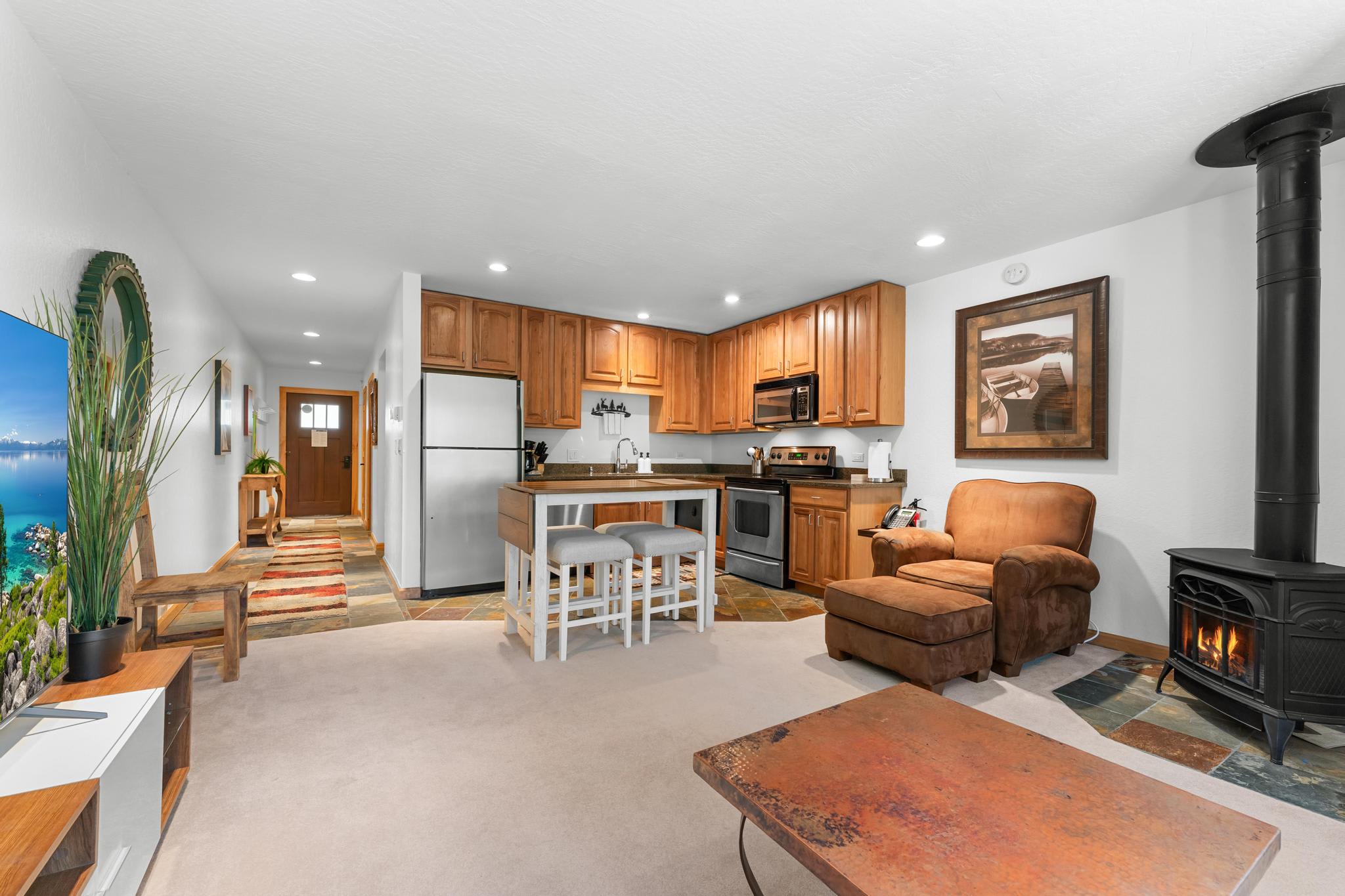 Cozy Truckee vacation rental with a modern kitchen, wood stove, and comfy armchair, perfect for a relaxing stay.