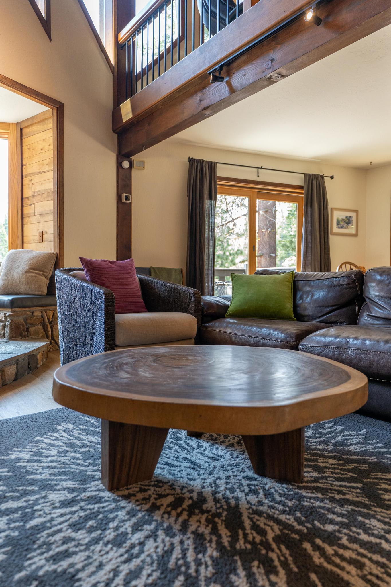 Cozy living room in a Tahoe Vista vacation rental with modern decor, large windows, and comfy seating.