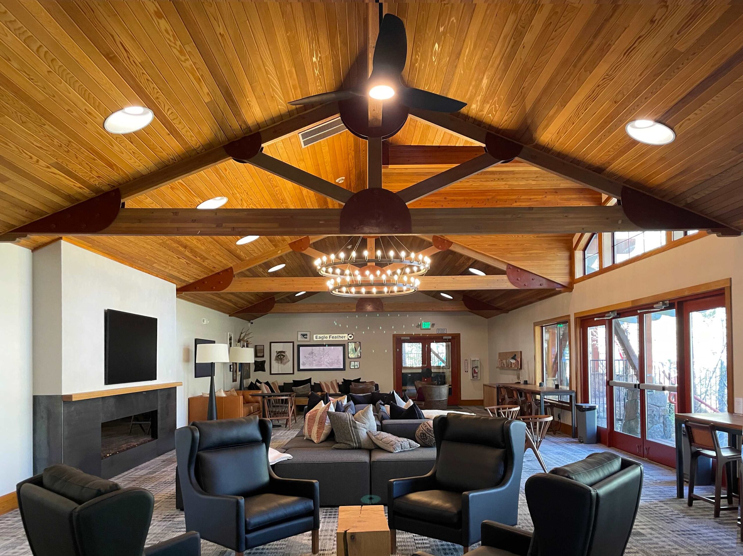 Spacious Truckee vacation rental living area with wooden ceiling, modern chandelier, and comfortable seating.