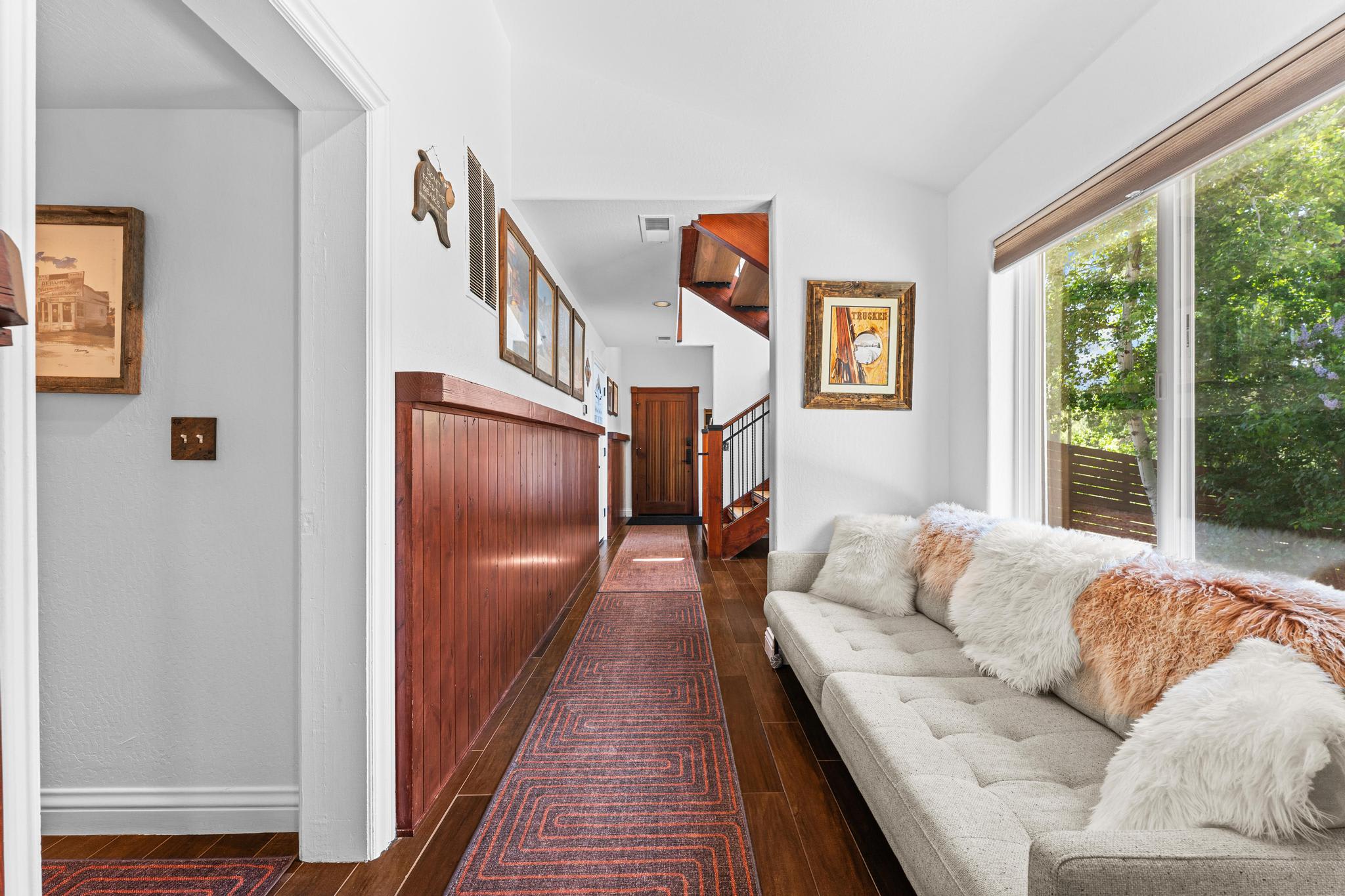 Hallway in a Truckee vacation rental with cozy decor, large window, and soft cushions on a light couch.