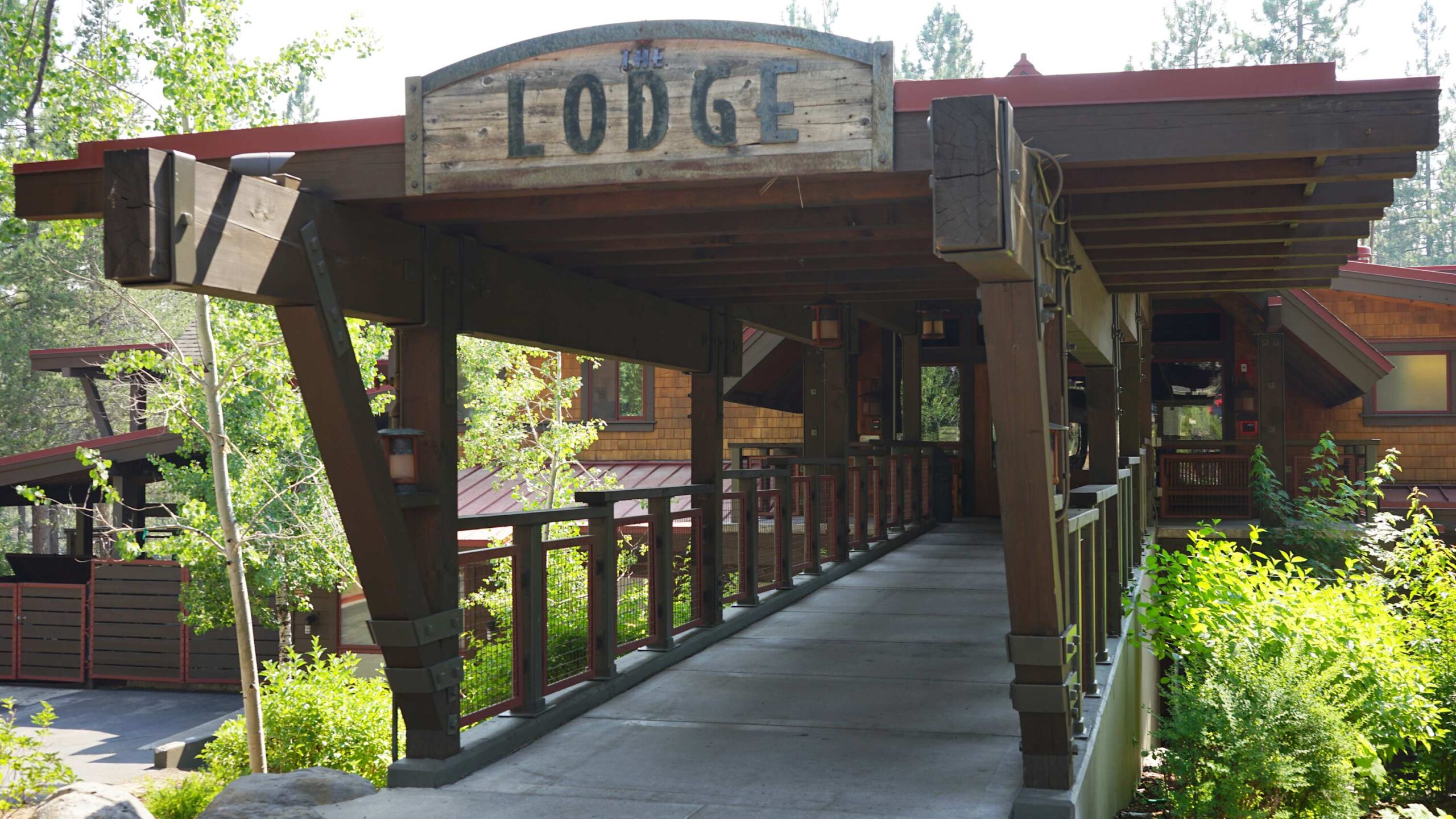 Wooden lodge entrance surrounded by greenery, a vacation rental located in the scenic city of Truckee.