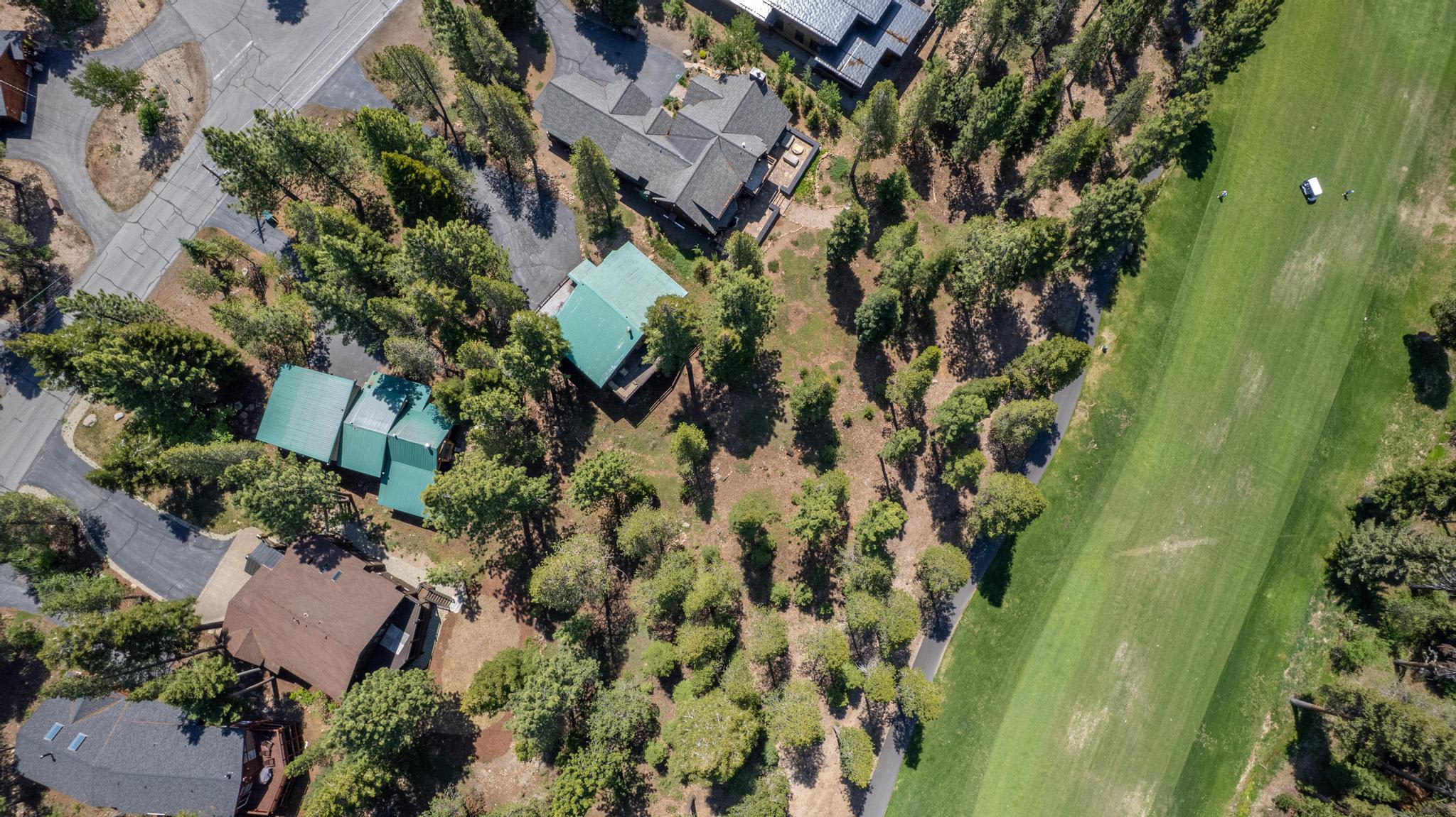 Aerial view of a Truckee neighborhood with pine trees, homes, and golf courses, ideal for vacation rental stays.