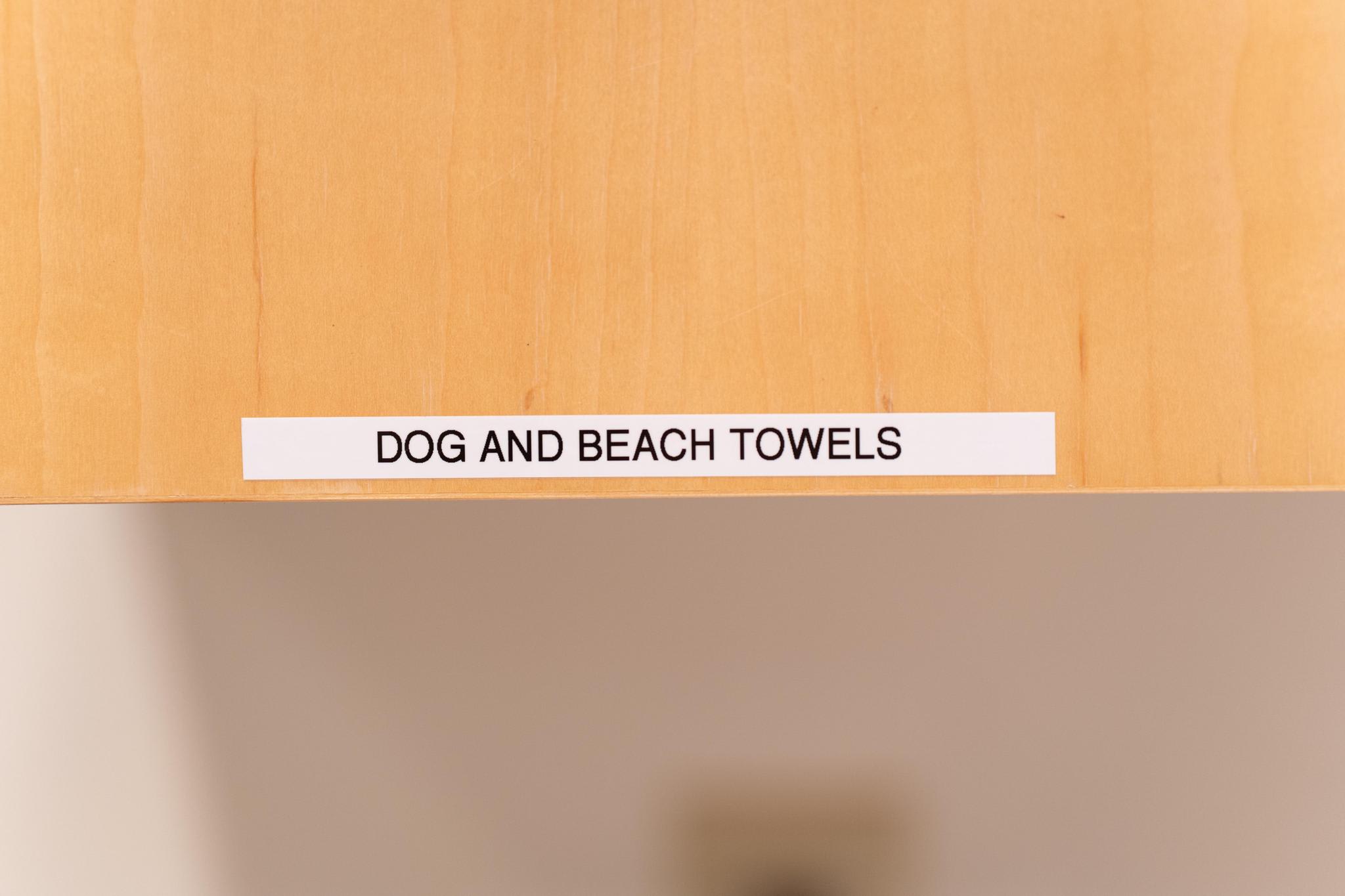 Label on a shelf reads "Dog and Beach Towels" inside a Tahoe Vista vacation rental.