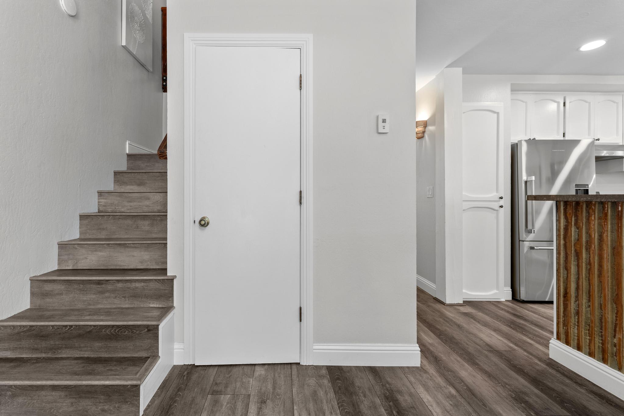 Staircase view in a modern Tahoe Vista vacation rental with wood flooring and a sleek kitchen area.