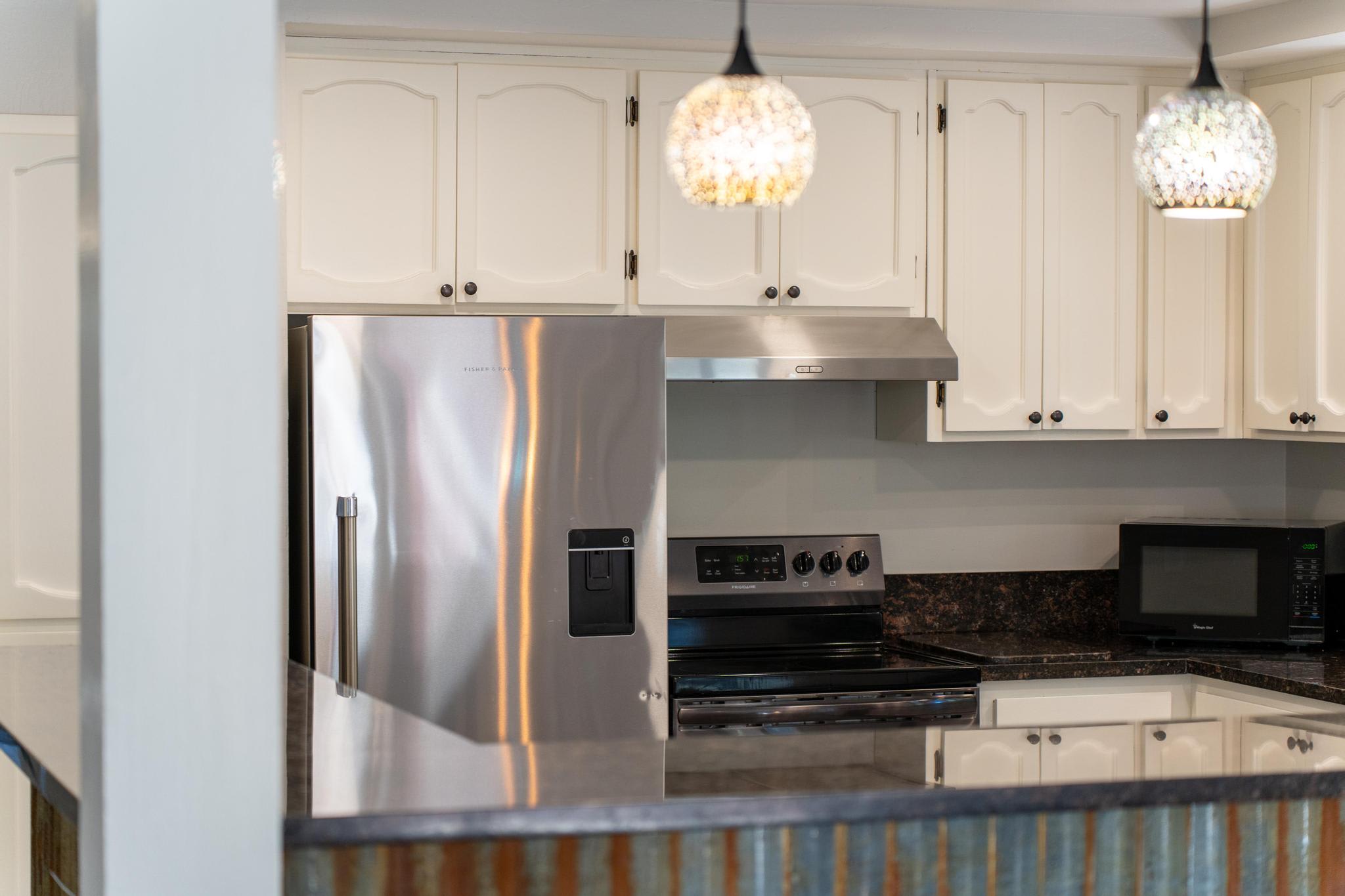 Modern kitchen in a Tahoe Vista vacation rental, featuring stainless steel appliances and elegant lighting.