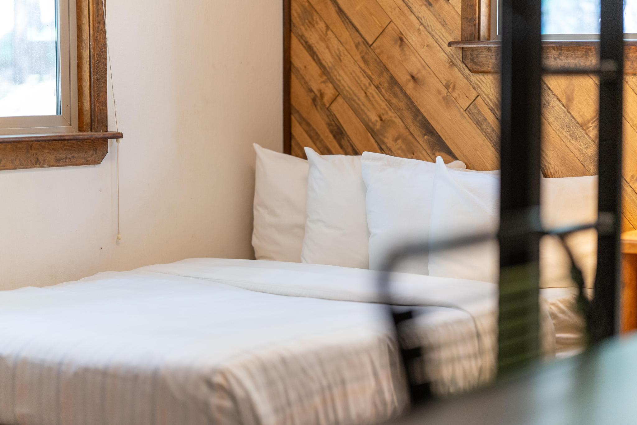 Cozy bedroom in a Tahoe Vista vacation rental with wood accents and soft white bedding.