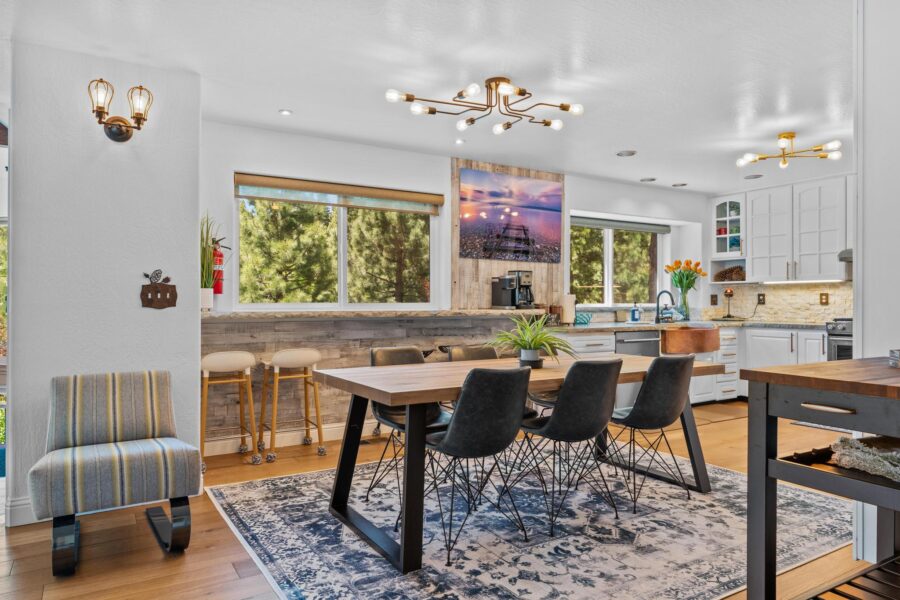 Modern kitchen and dining area in a Truckee vacation rental, featuring elegant lighting and forest views.
