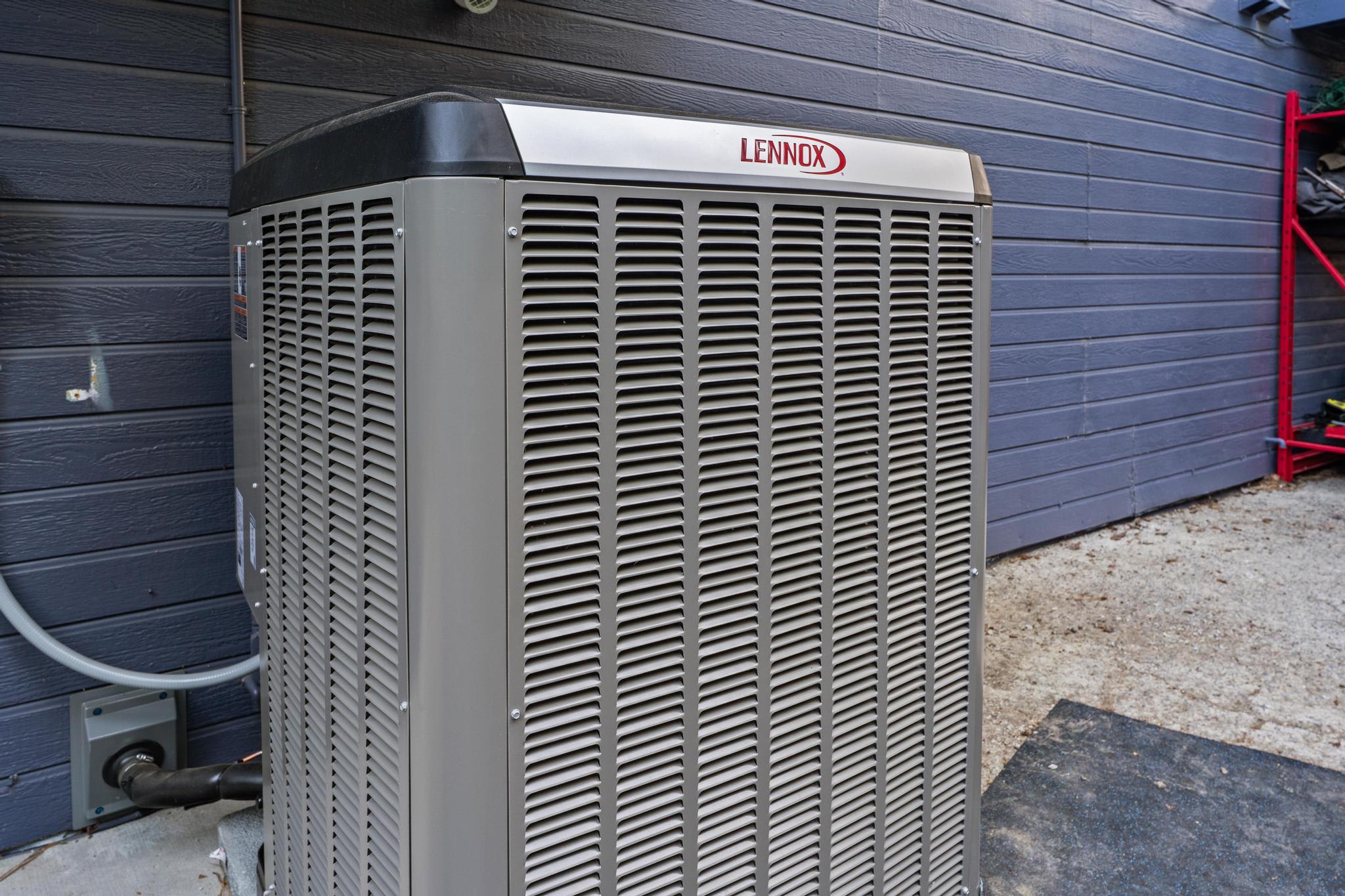 Outdoor air conditioning unit next to a Truckee vacation rental with a grey siding backdrop.