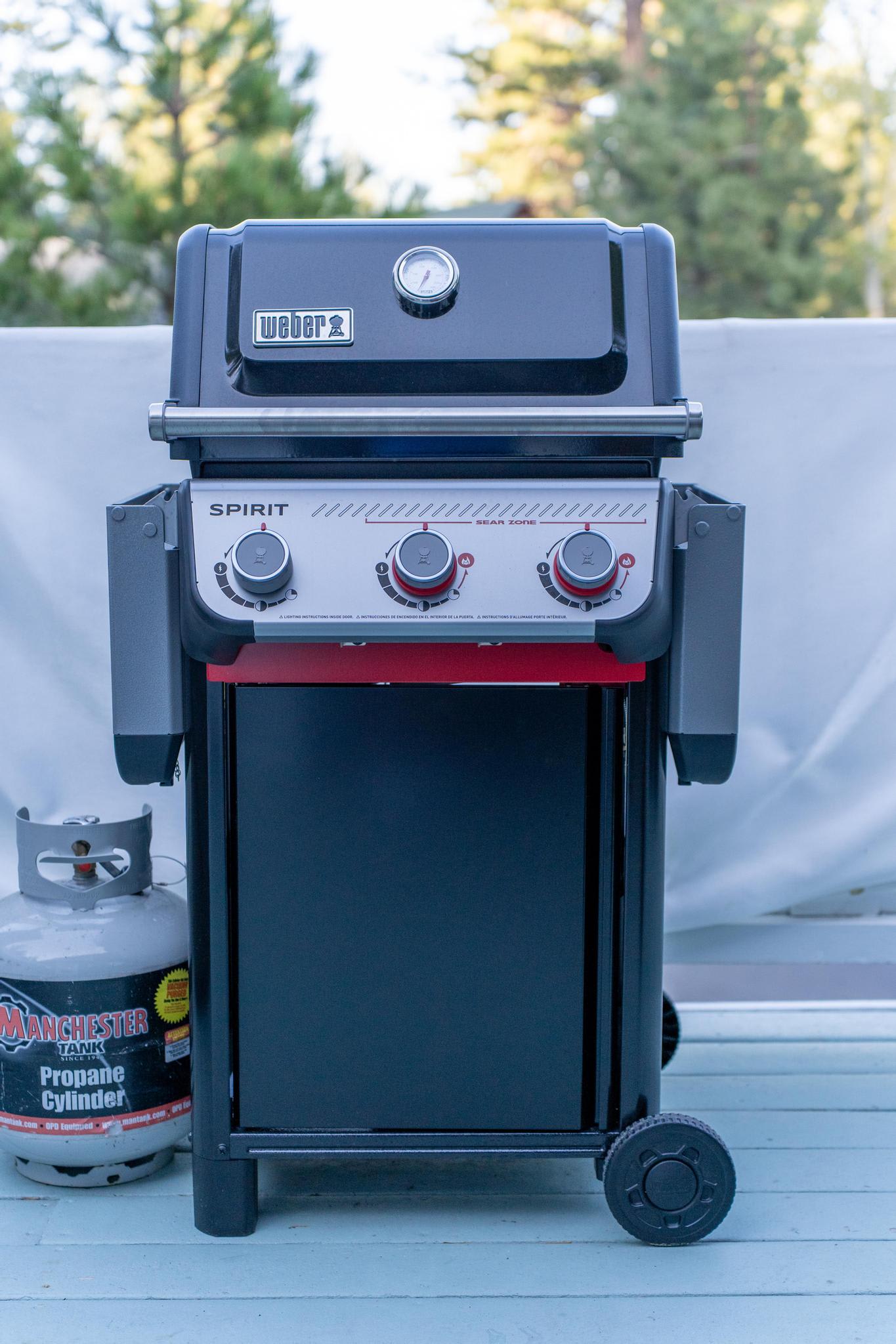 Outdoor grill on a deck at a Truckee vacation rental, with a propane tank beside it.