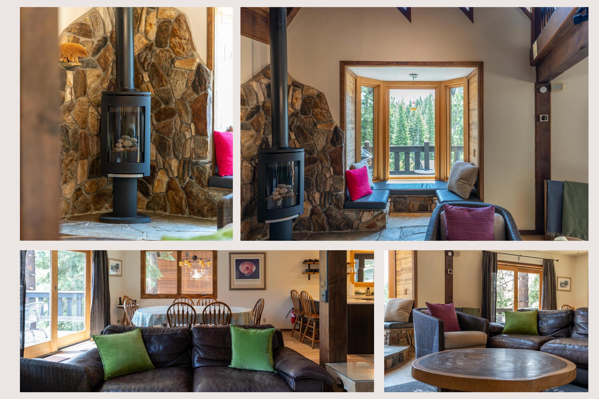 Cozy Tahoe Vista vacation rental interior with a rustic fireplace, comfy seating, and forest views through large windows.