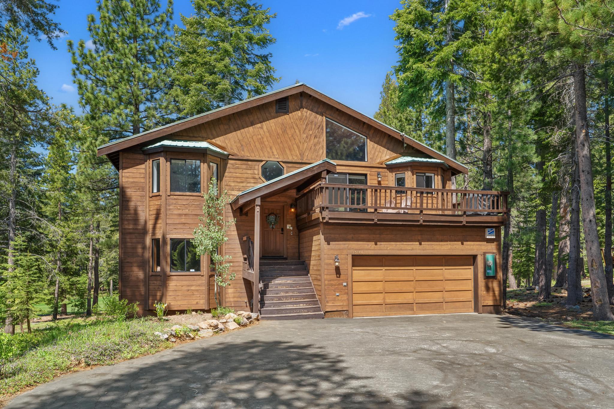 Wooden cabin surrounded by trees in Truckee, ideal vacation rental with large deck and garage.