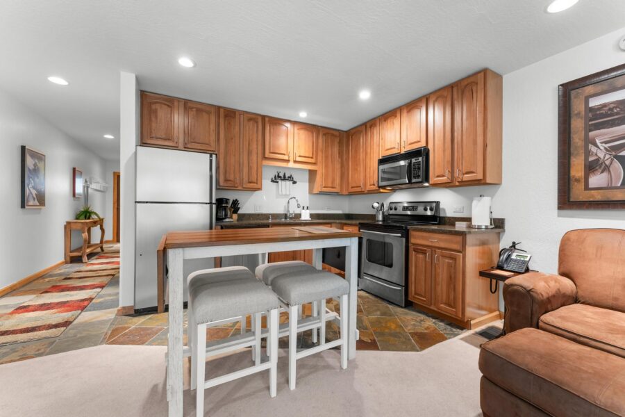 Modern kitchen in a Truckee vacation rental with wooden cabinets, stainless appliances, and cozy seating.