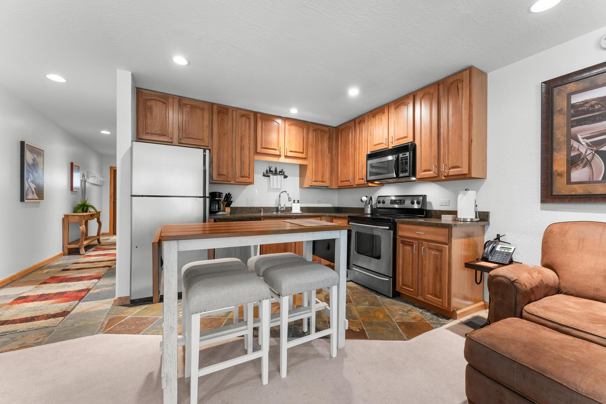 Modern kitchen in a Truckee vacation rental with wooden cabinets, stainless appliances, and cozy seating.