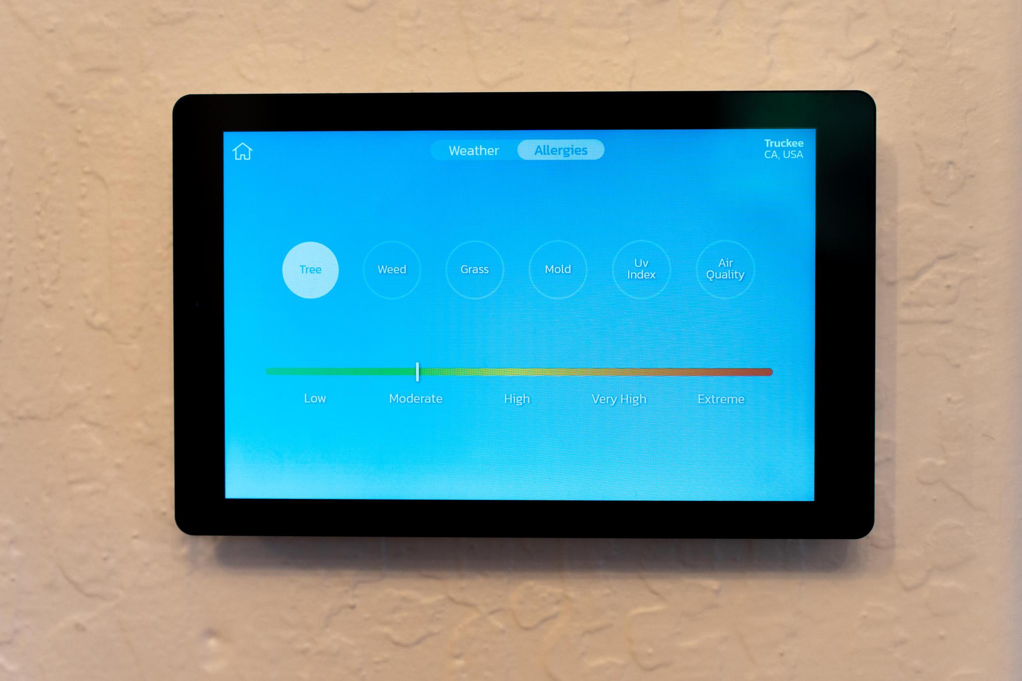 Smart tablet on wall in Truckee vacation rental, displaying allergy and air quality data.