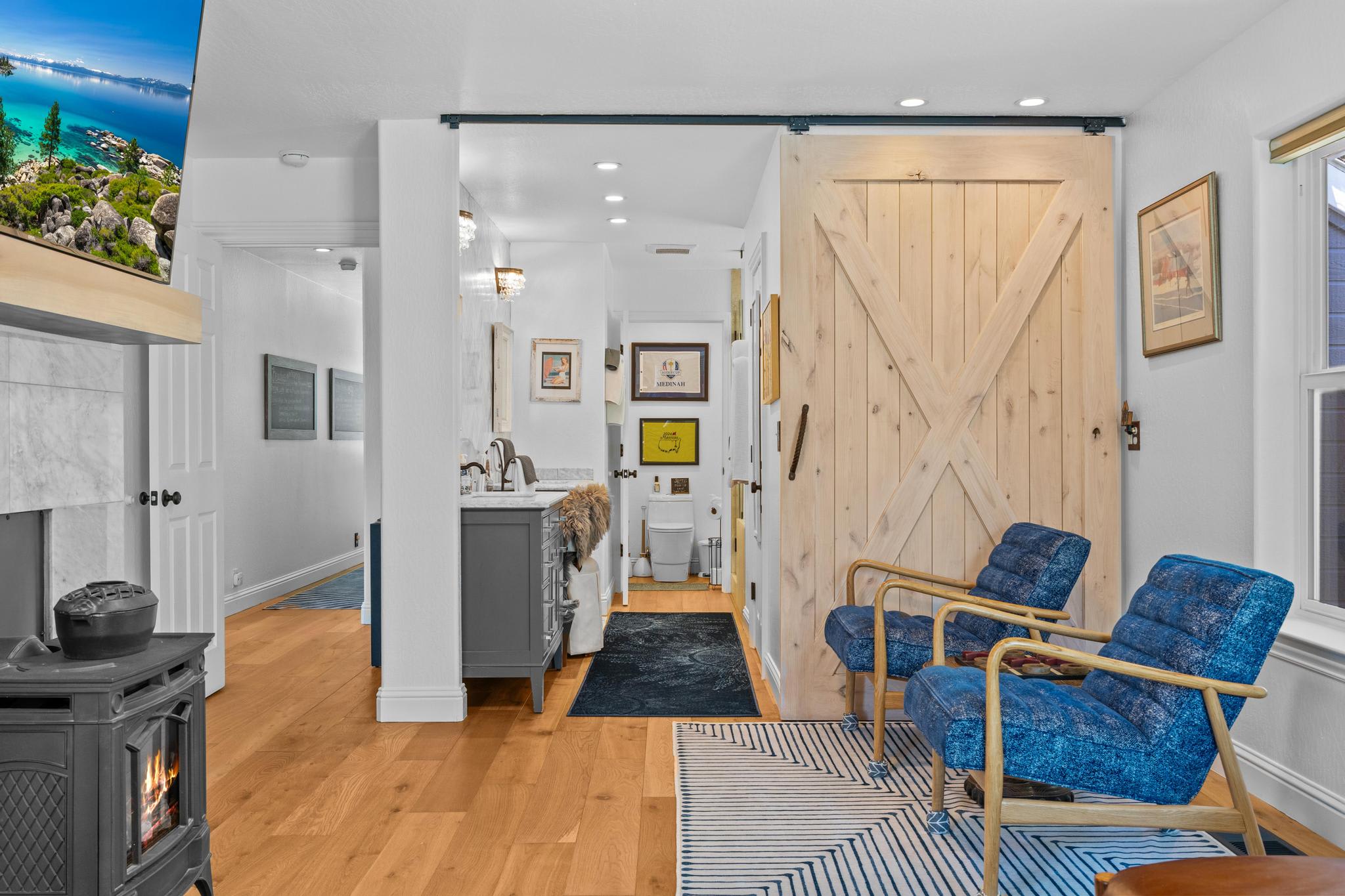 Cozy Truckee vacation rental with blue chairs, wood accents, and modern decor, featuring a warm fireplace and bright ambiance.