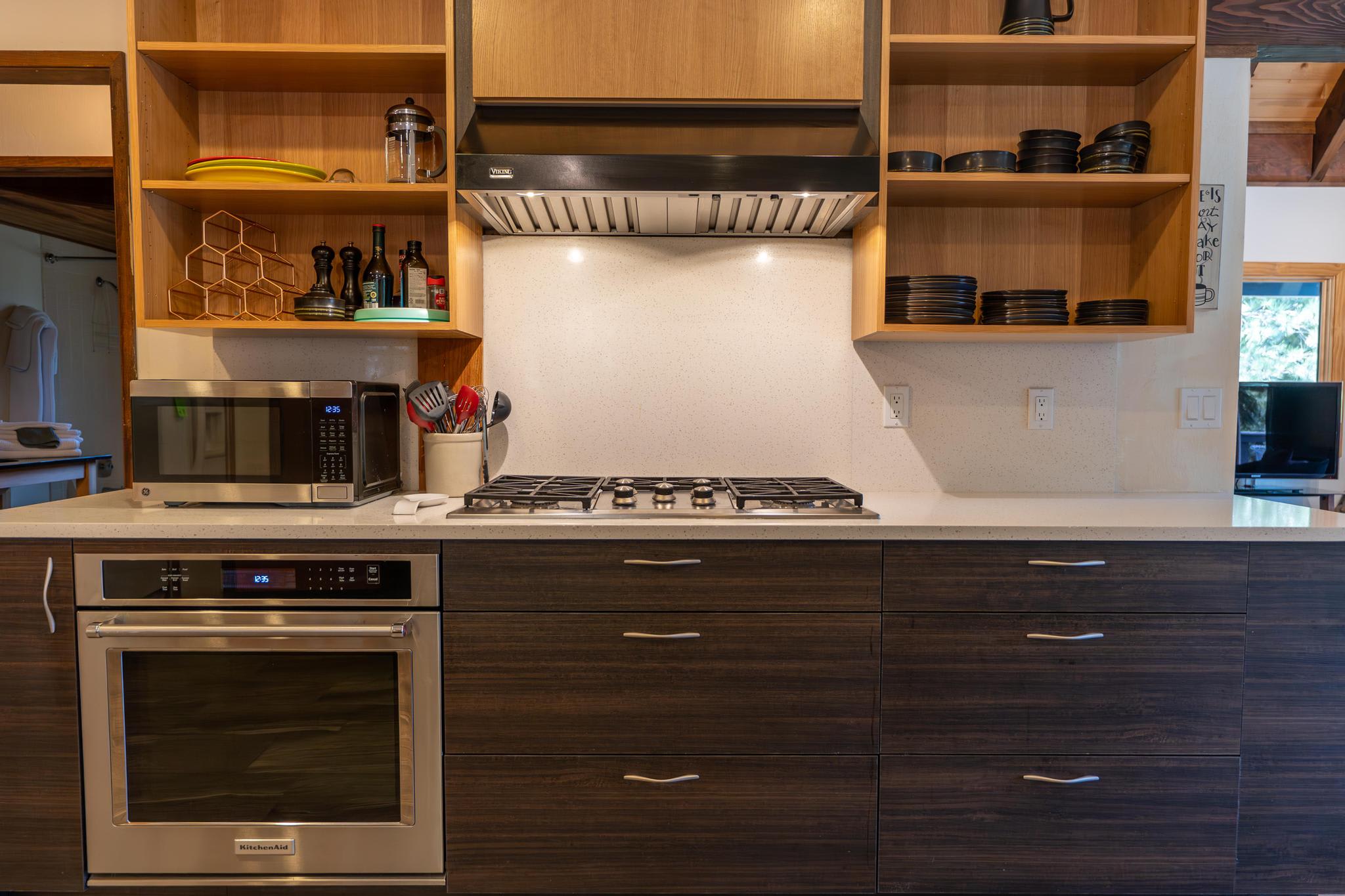 Modern kitchen in a Tahoe Vista vacation rental, featuring wooden cabinets, a gas stove, microwave, and oven.