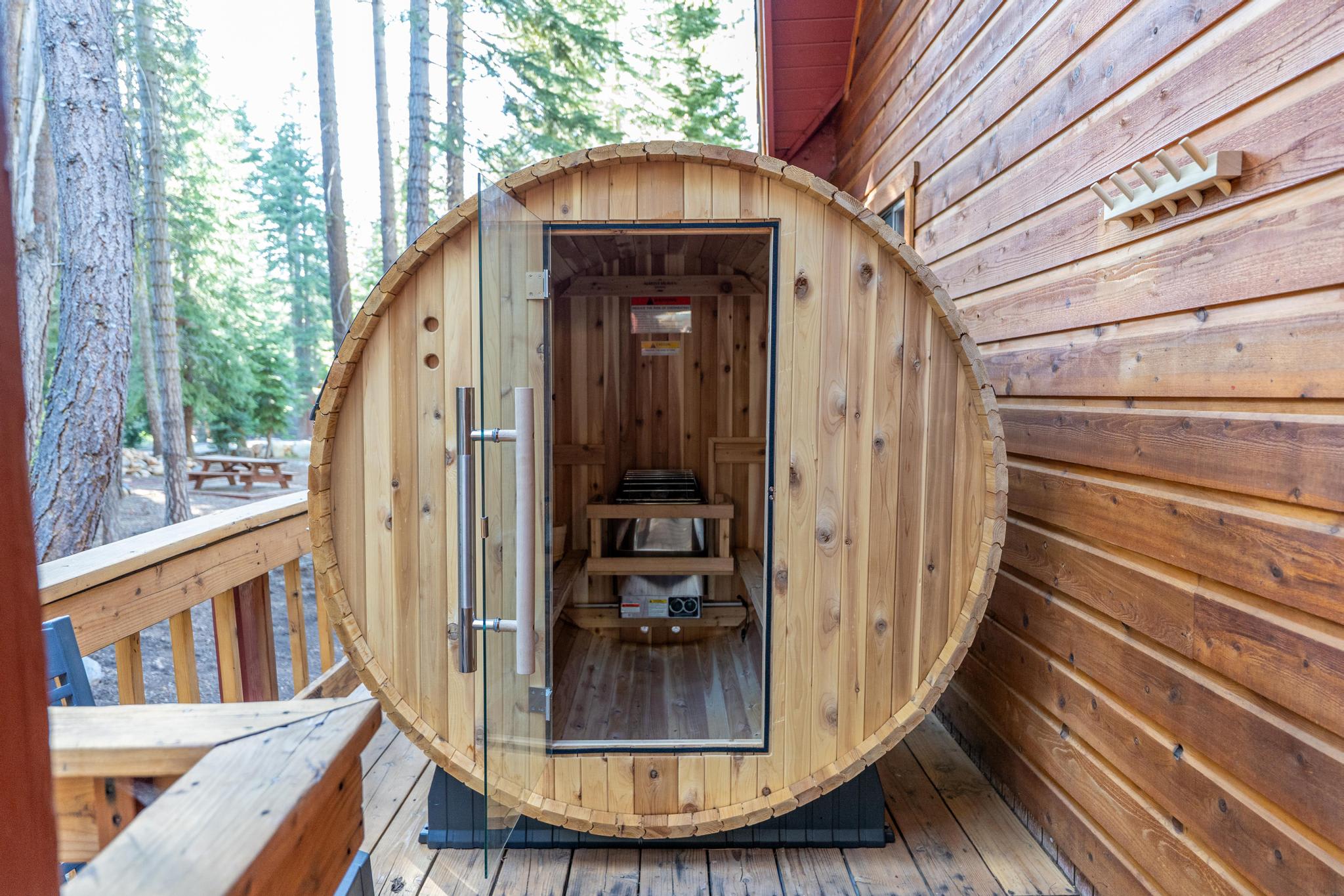 Wooden barrel sauna on a deck surrounded by trees in a Tahoe Vista vacation rental.