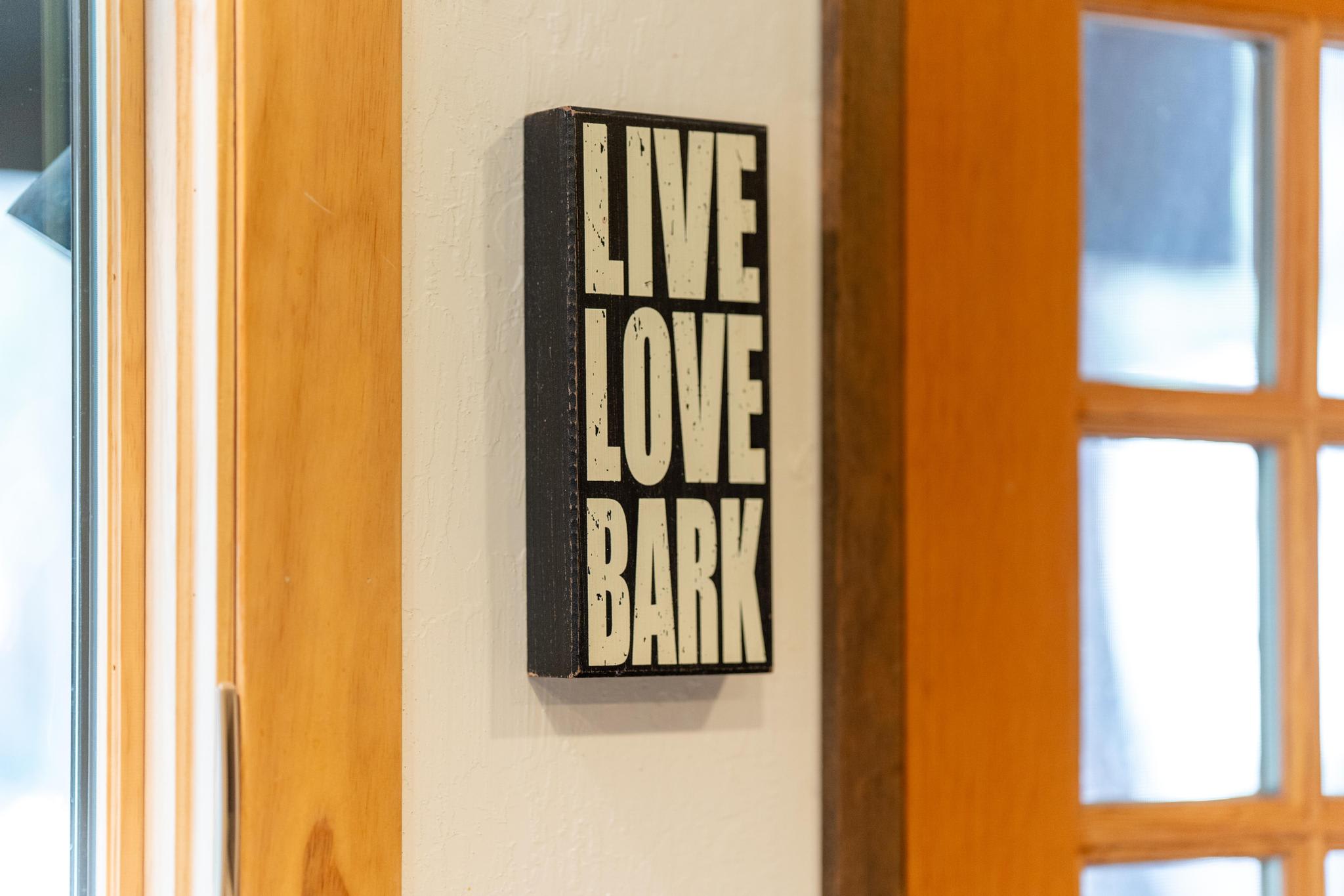 Decorative sign reading "Live Love Bark" in a Tahoe Vista vacation rental. Warm wooden interior details.