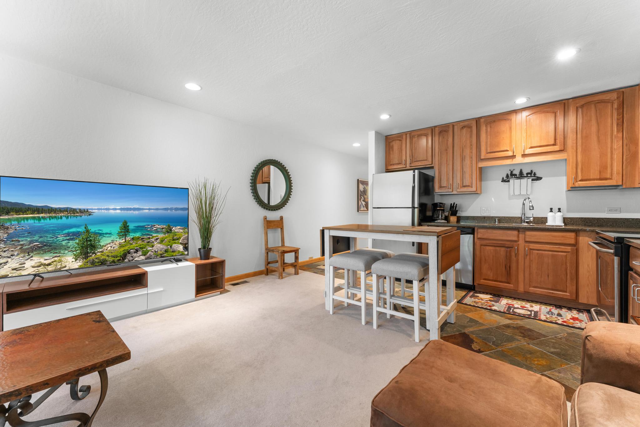 Modern Truckee vacation rental with cozy living space, kitchen, and bright decor featuring a TV with scenic views.