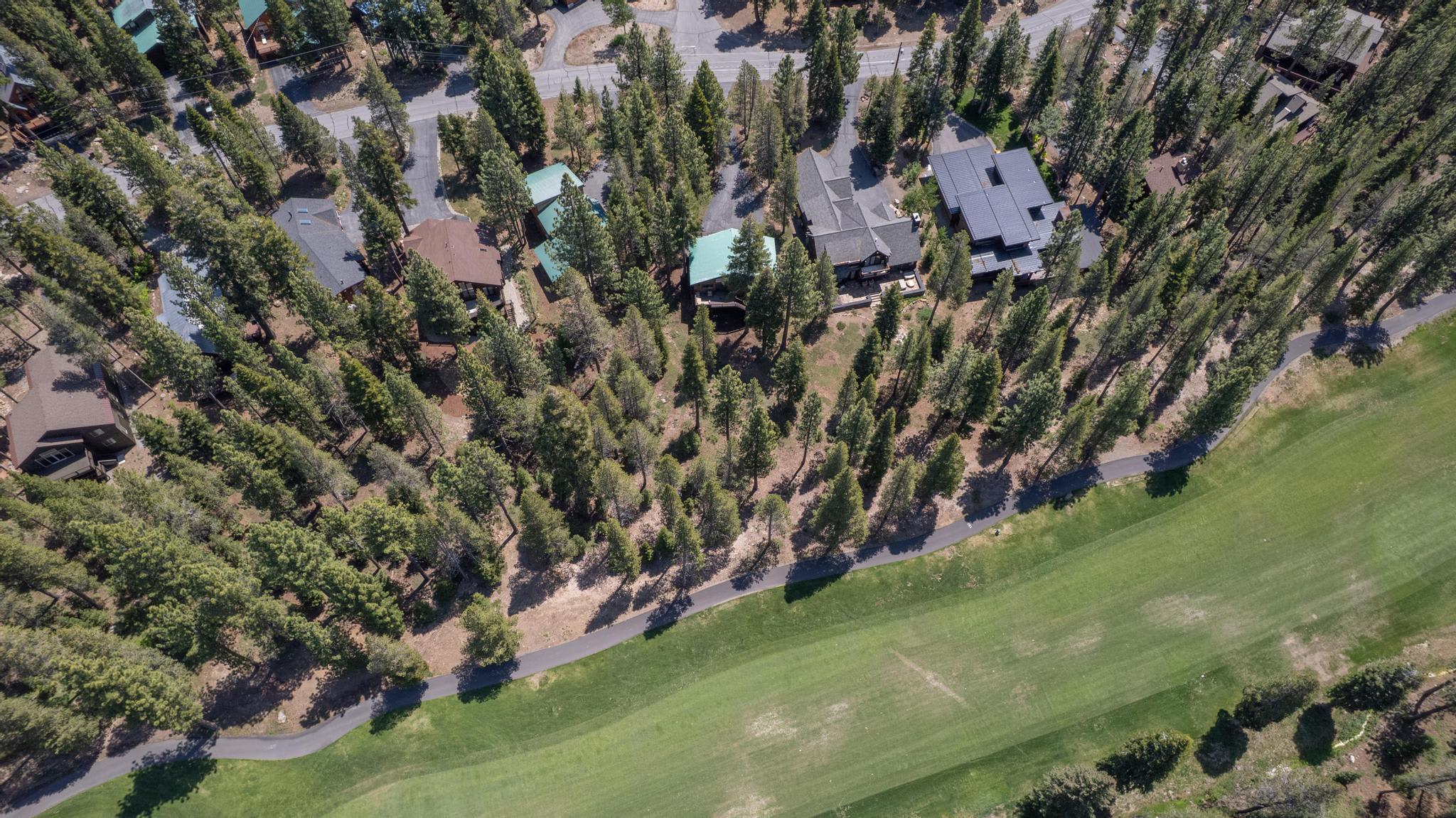Aerial view of vacation rental homes surrounded by trees near a golf course in Truckee.